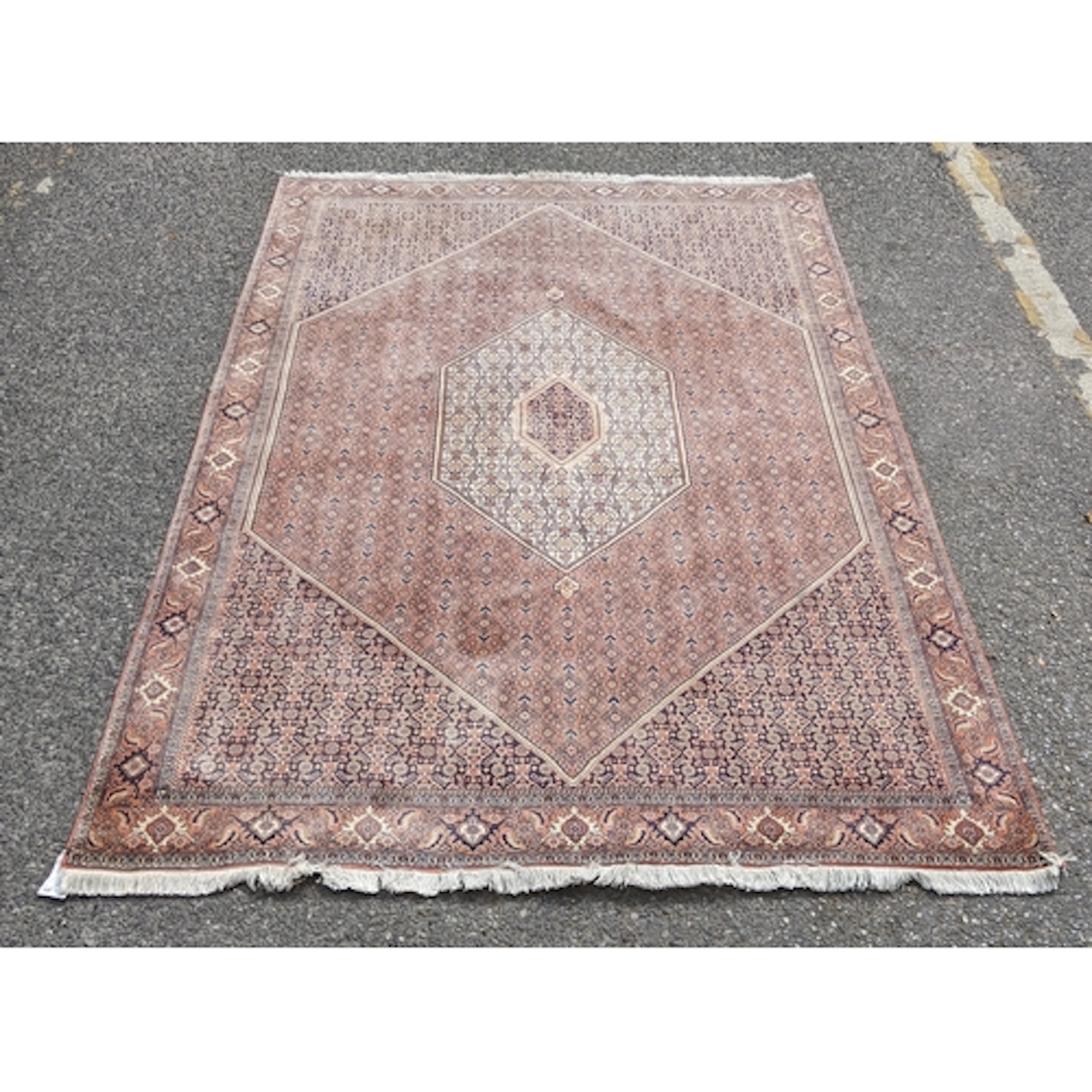 A Persian Bijar rug with an intricate symmetrical design env...