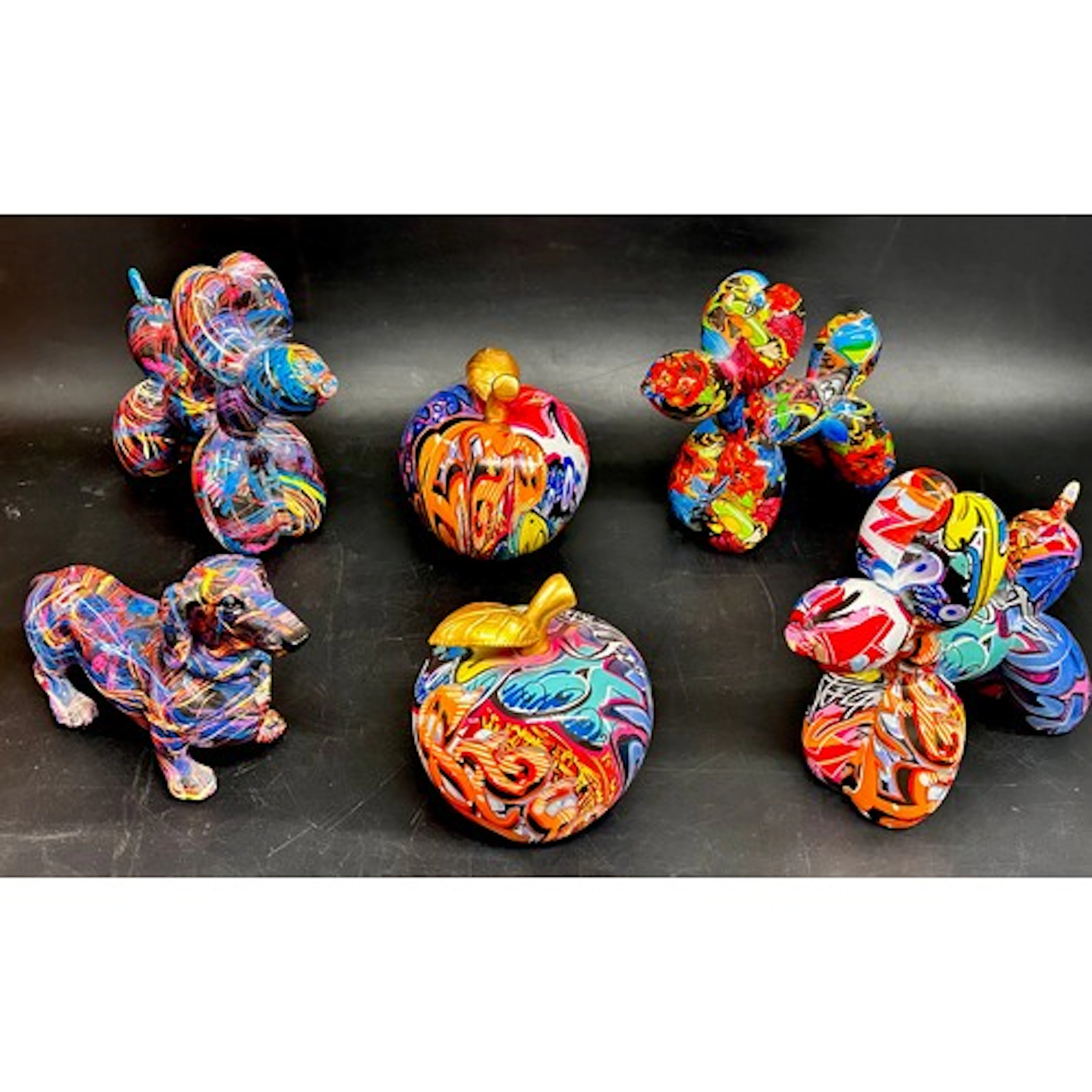 Four multi-coloured animal figures and two similar apple scu...