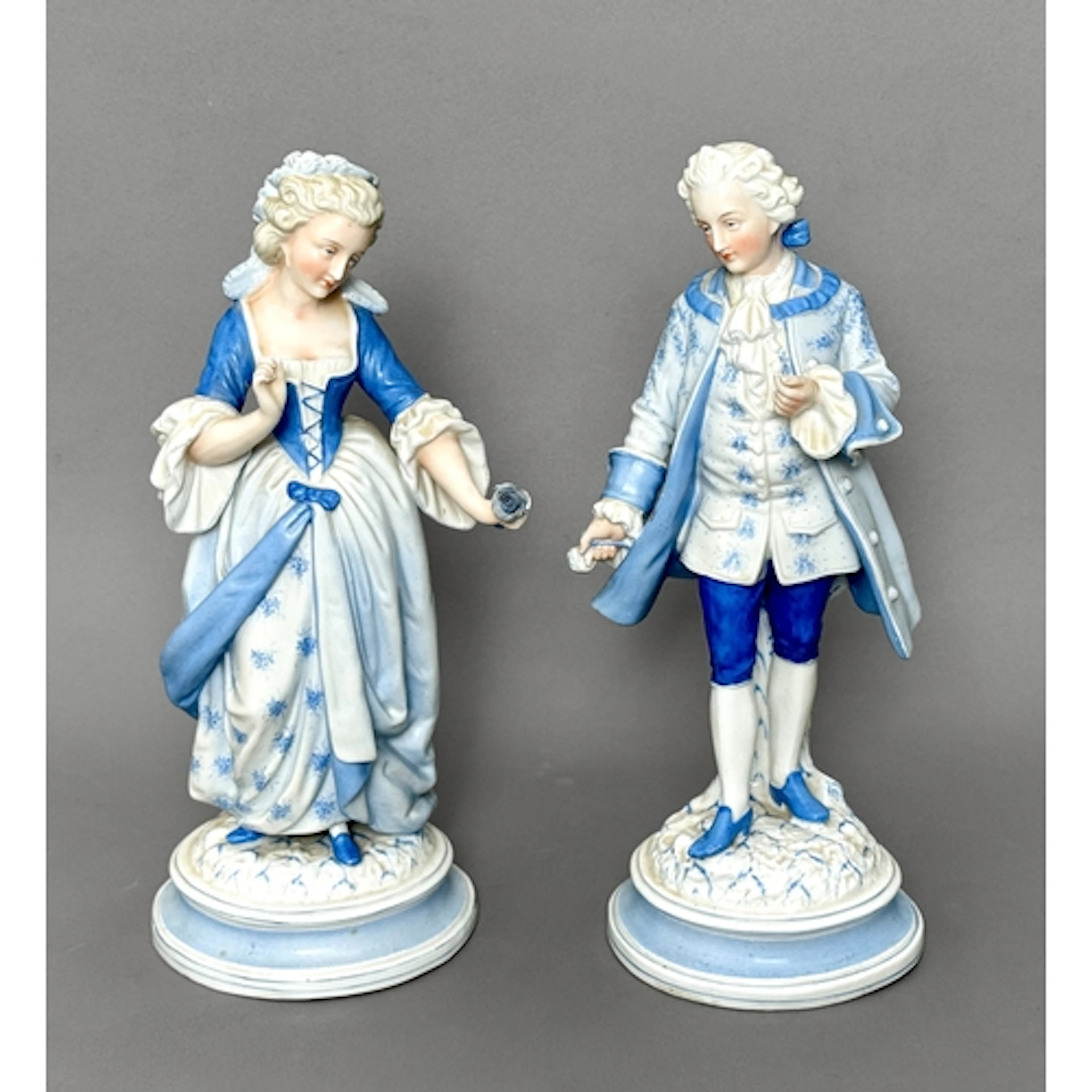 A pair of German porcelain figures of a dandy and maiden - e...