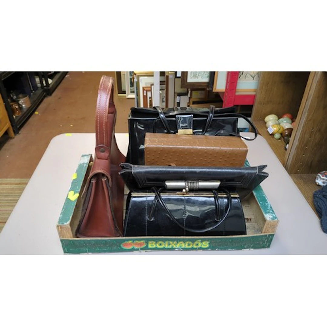 A group of five handbags and clutches in brown and black, in...