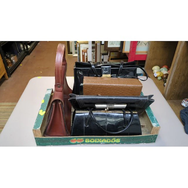 A group of five handbags and clutches in brown and black, in...
