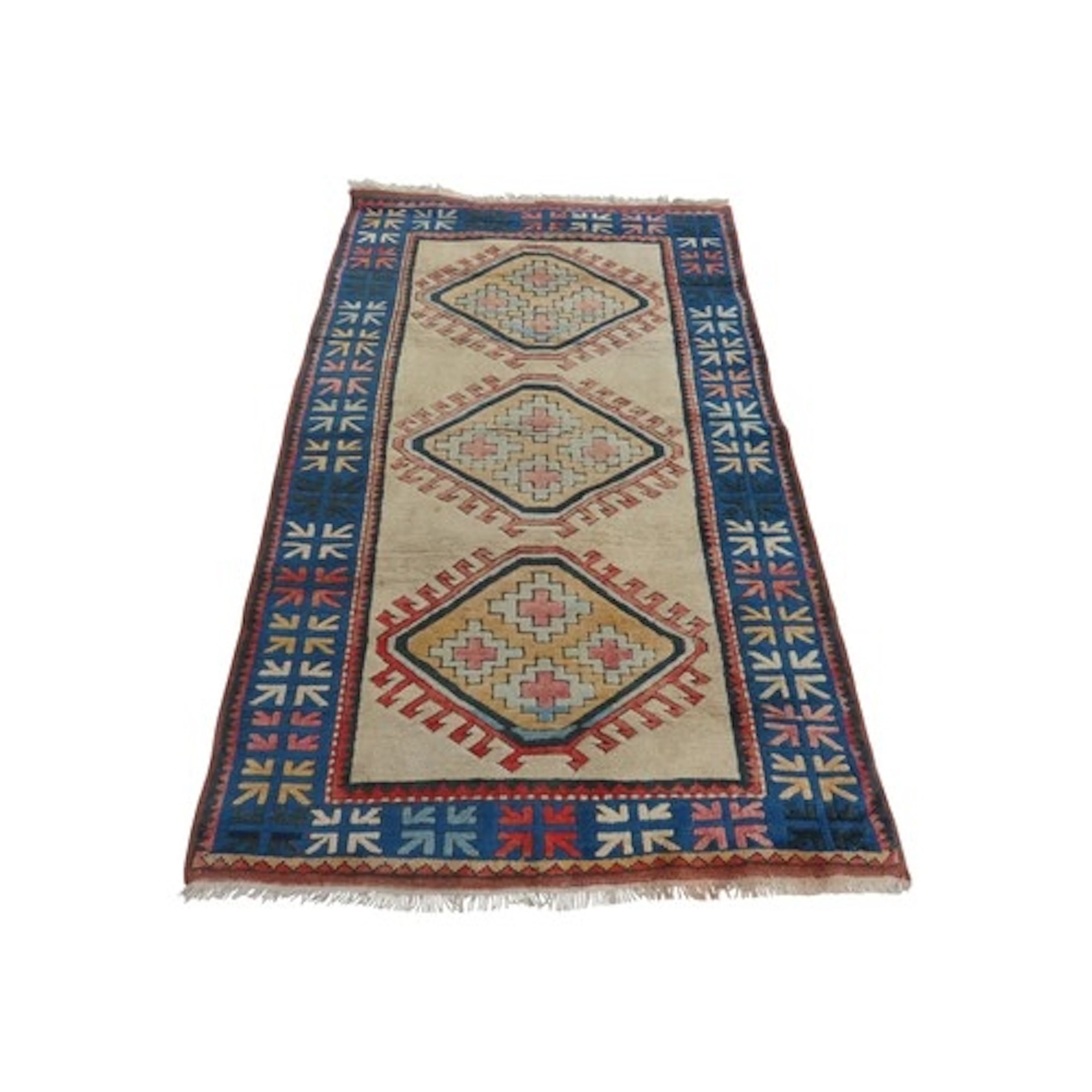 A Turkish wool carpet with a white ground and a triple medal...