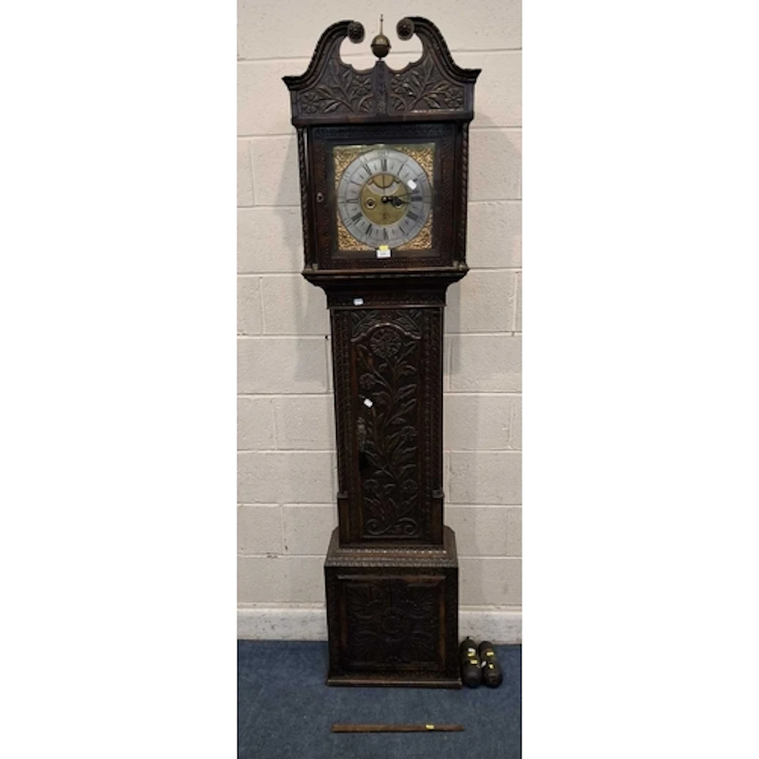 AN OAK CASED LONGCASE CLOCK, with geometric and foliate carv...