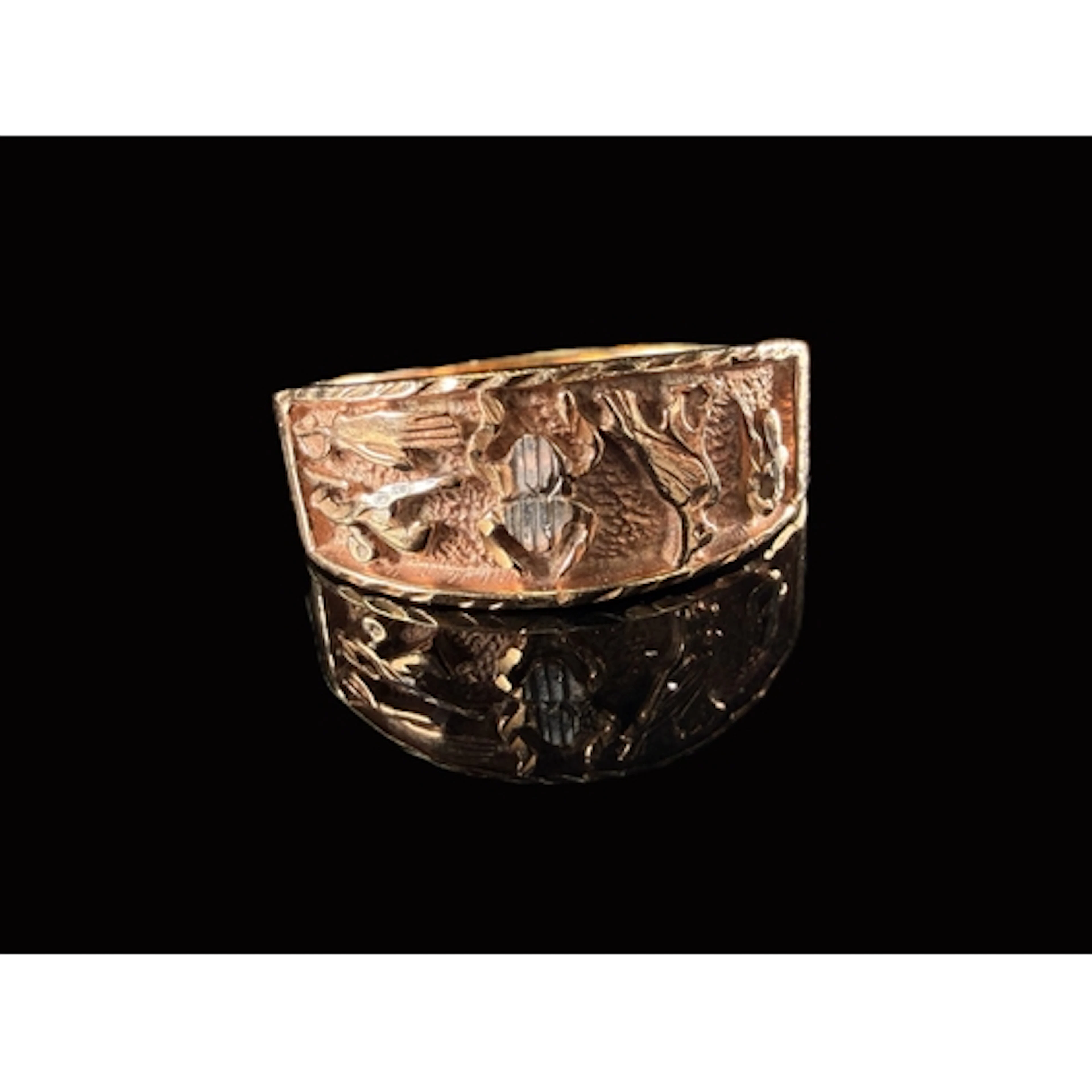 A 9 carat gold ring with an embossed textured Egyptian desig...