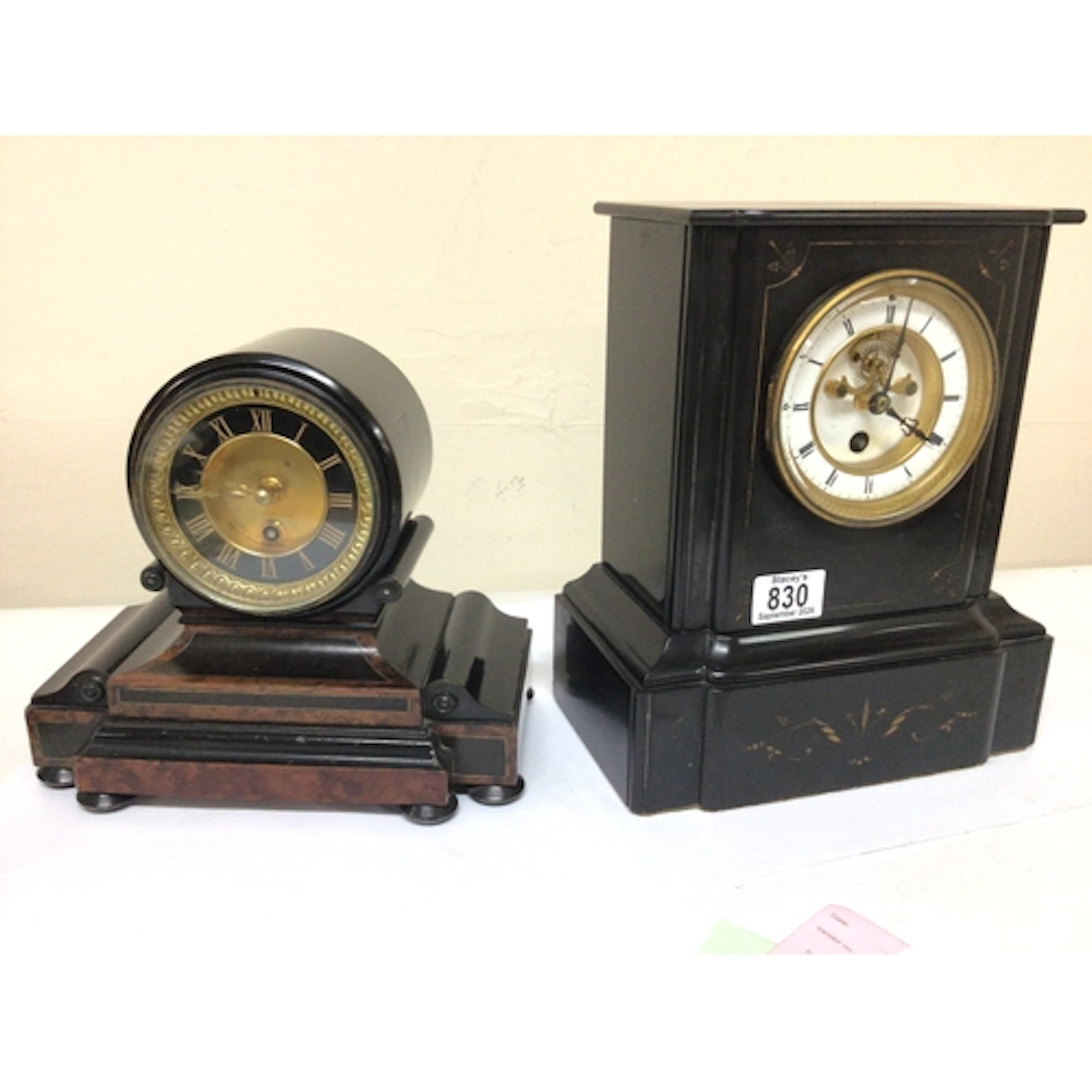 A Victorian black slate mantel clock with a visible es...