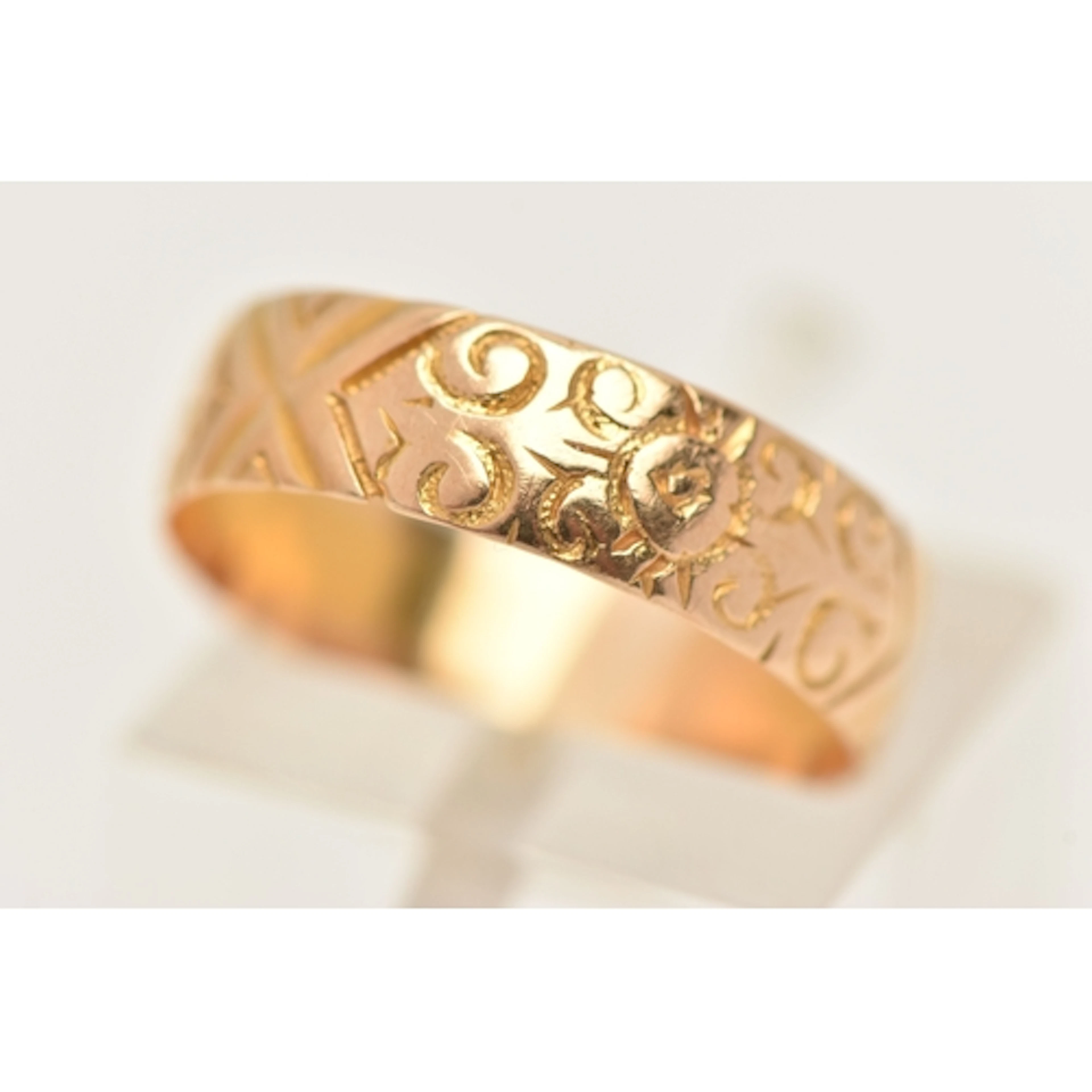 AN EARLY 20TH CENTURY 18CT GOLD FLORAL PATTERN WIDE BAND RIN...