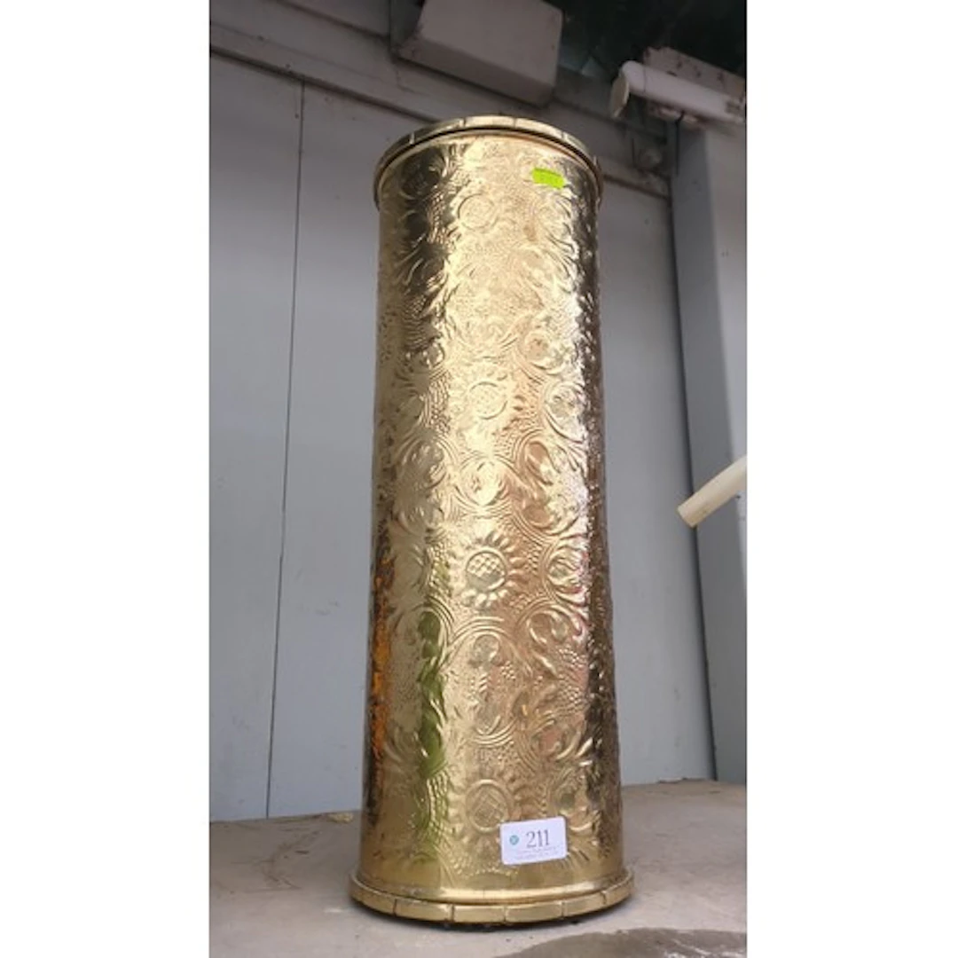 Brass stick stand embossed throughout with scrolling vines.