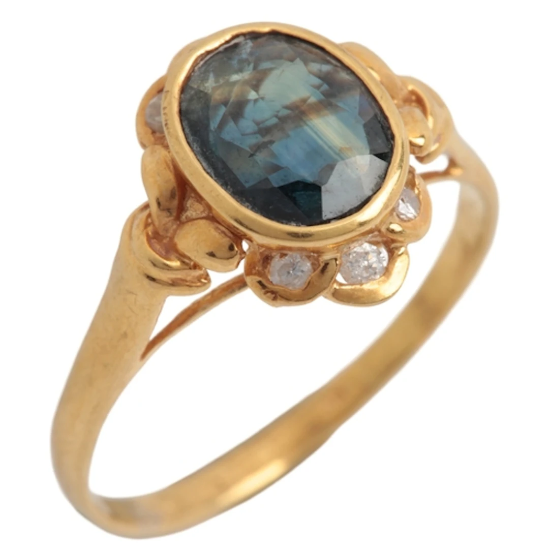 A sapphire and diamond ring, collet-set with an oval sapphir...