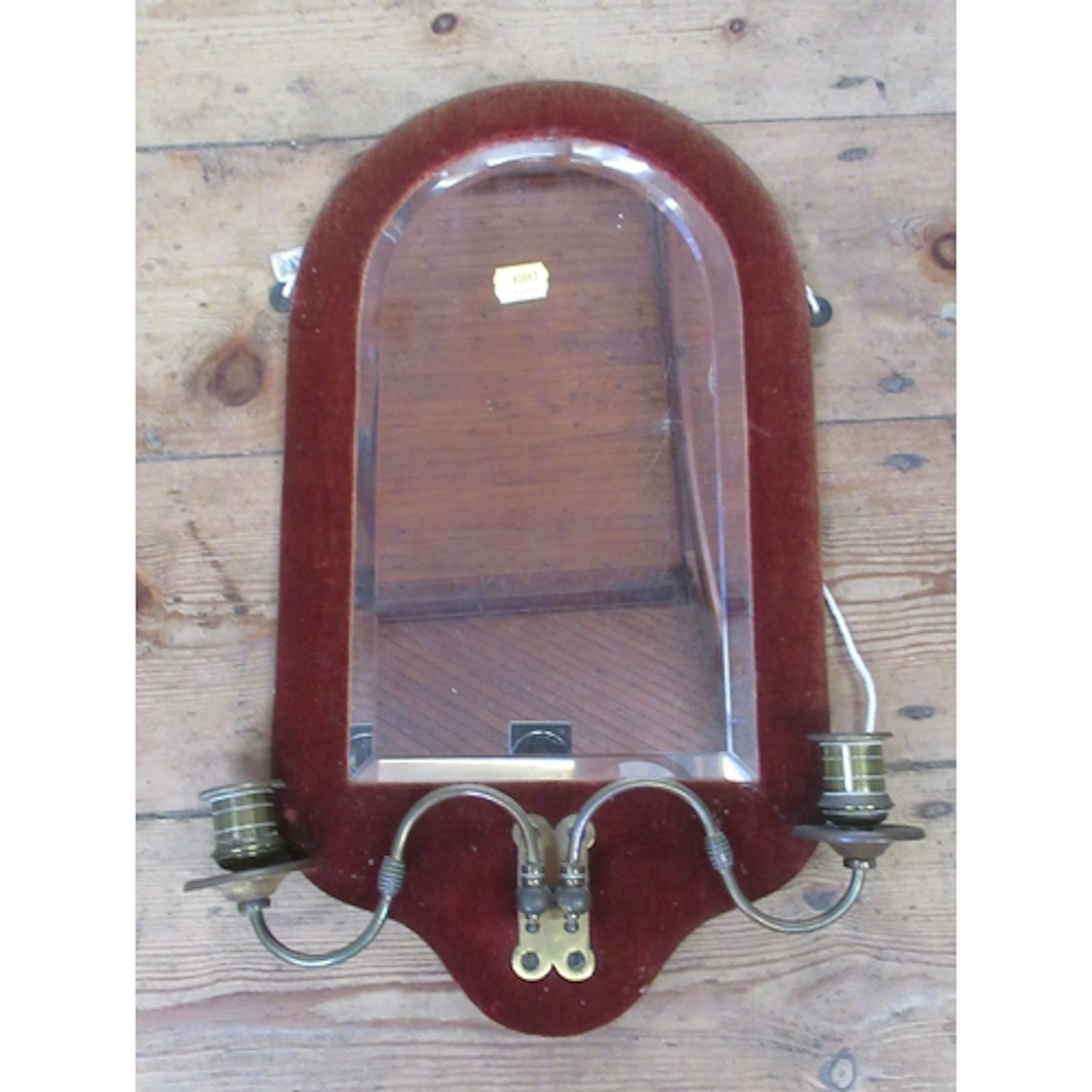 An arch top wall mirror, with velvet covered frame and a pai...