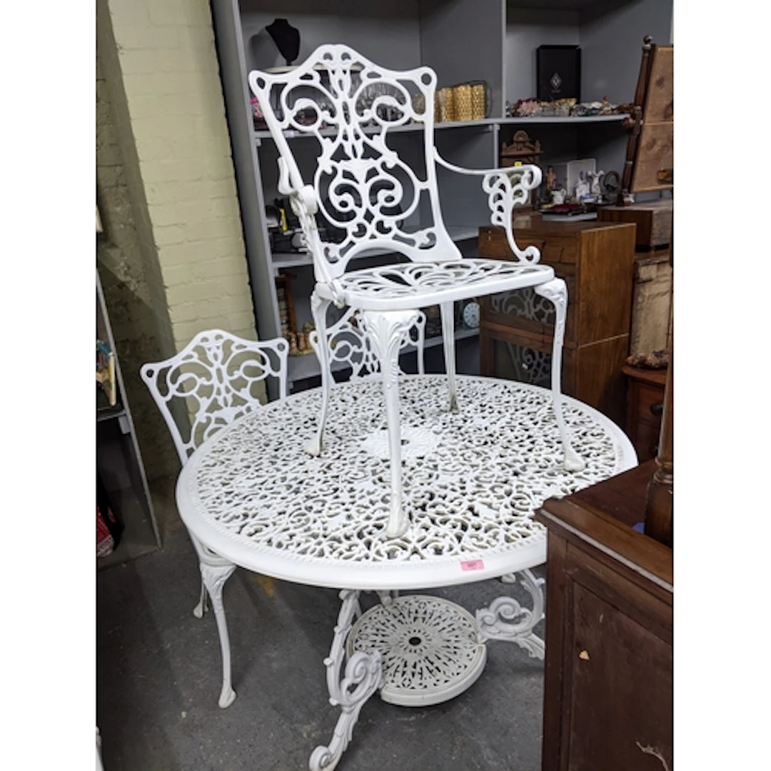 A white painted metal garden table, circular top with space ...