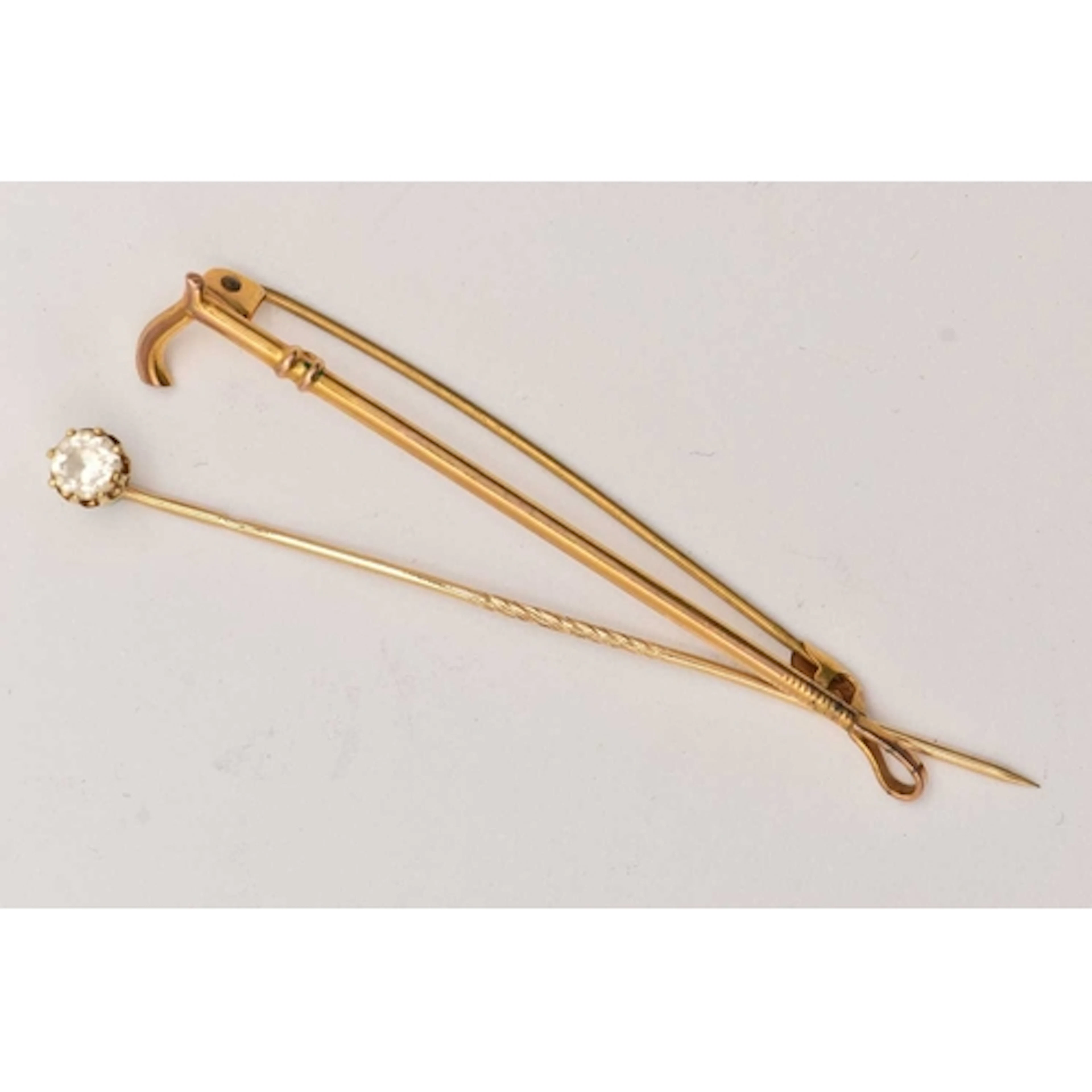 A BROOCH AND STICK PIN, a yellow metal riding crop, approxim...