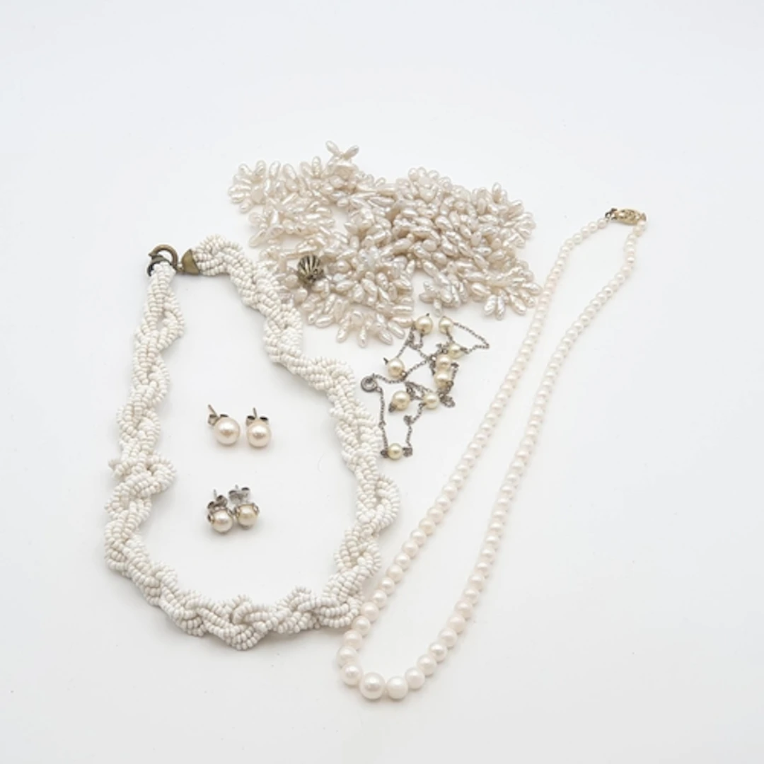A Chain stamped 'STERLING' strung with nine cultured pearl s...