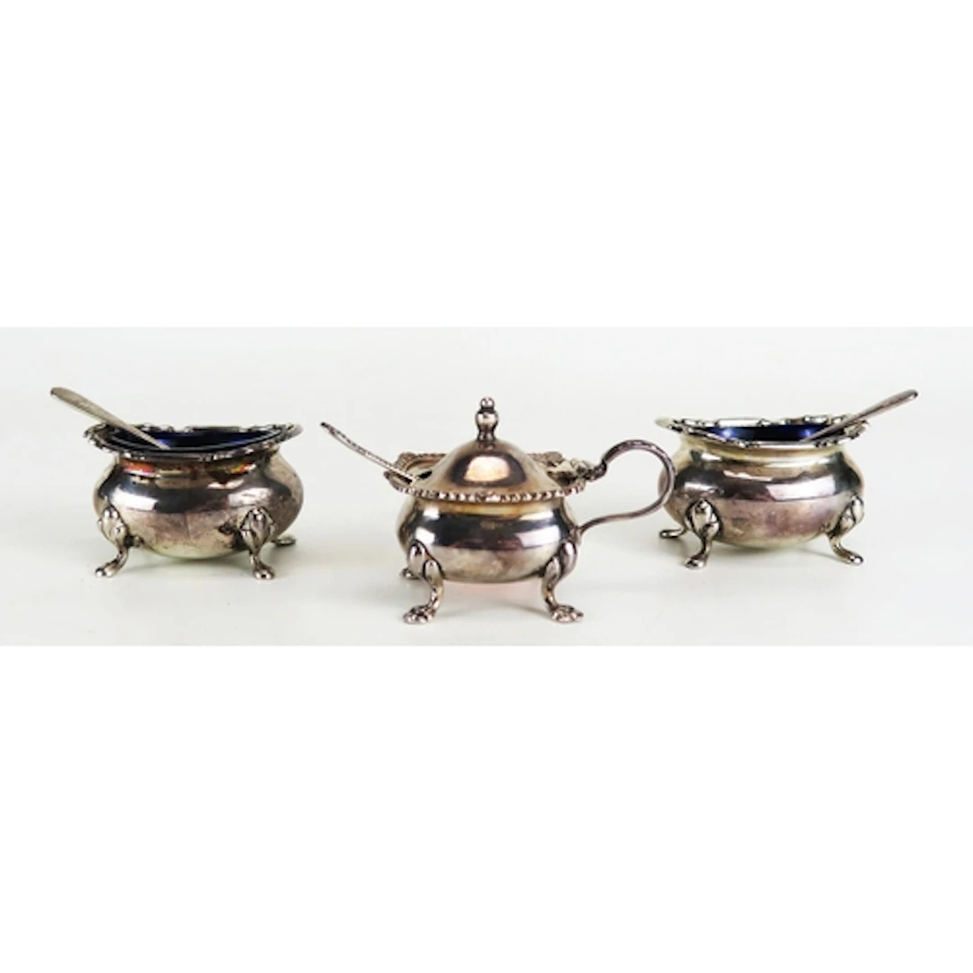 A matched three-piece silver condiment set, various makers a...