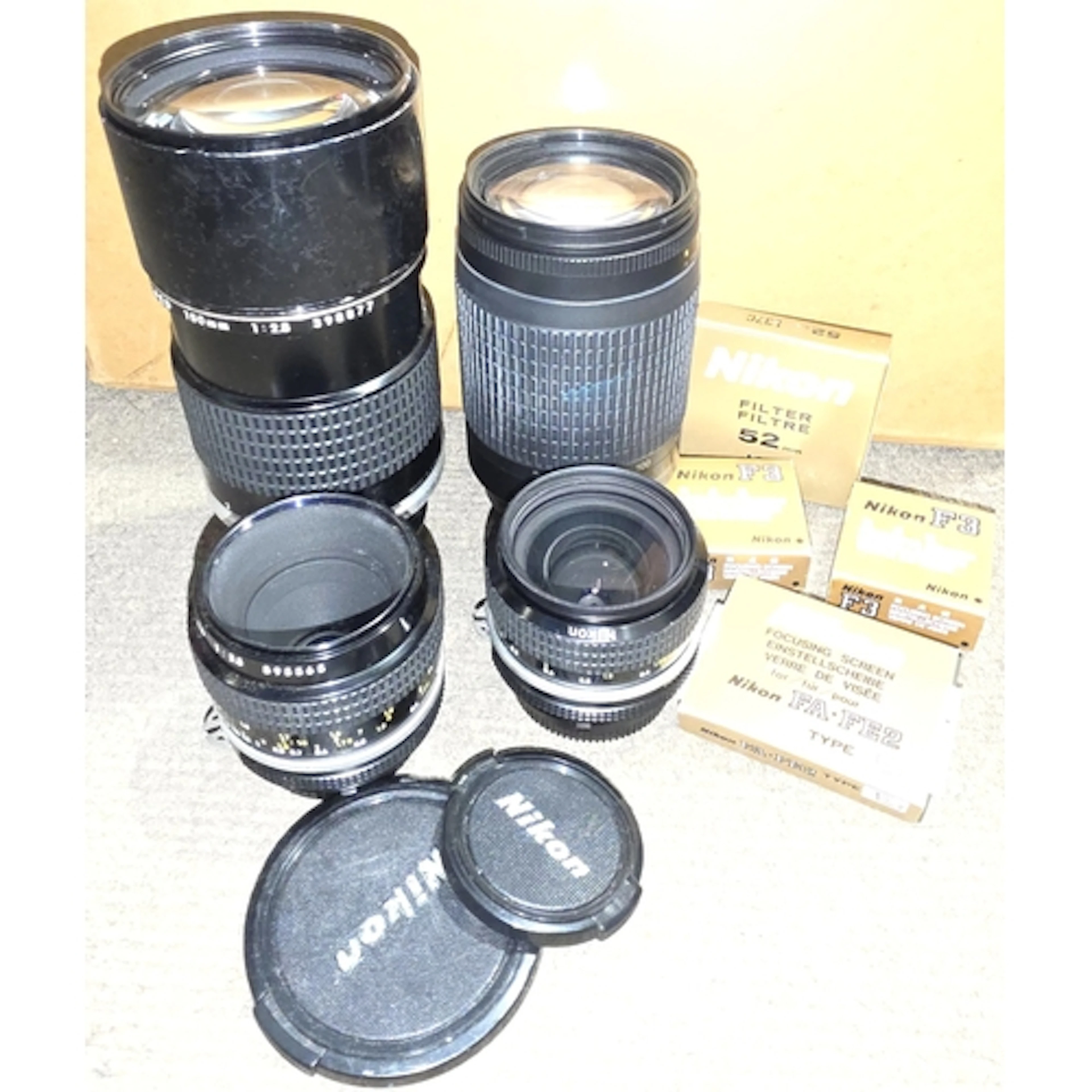 Four Nikon Nikkor lenses AF 70-300mm, 1:4-5.6G, 180mm 1:28, ...