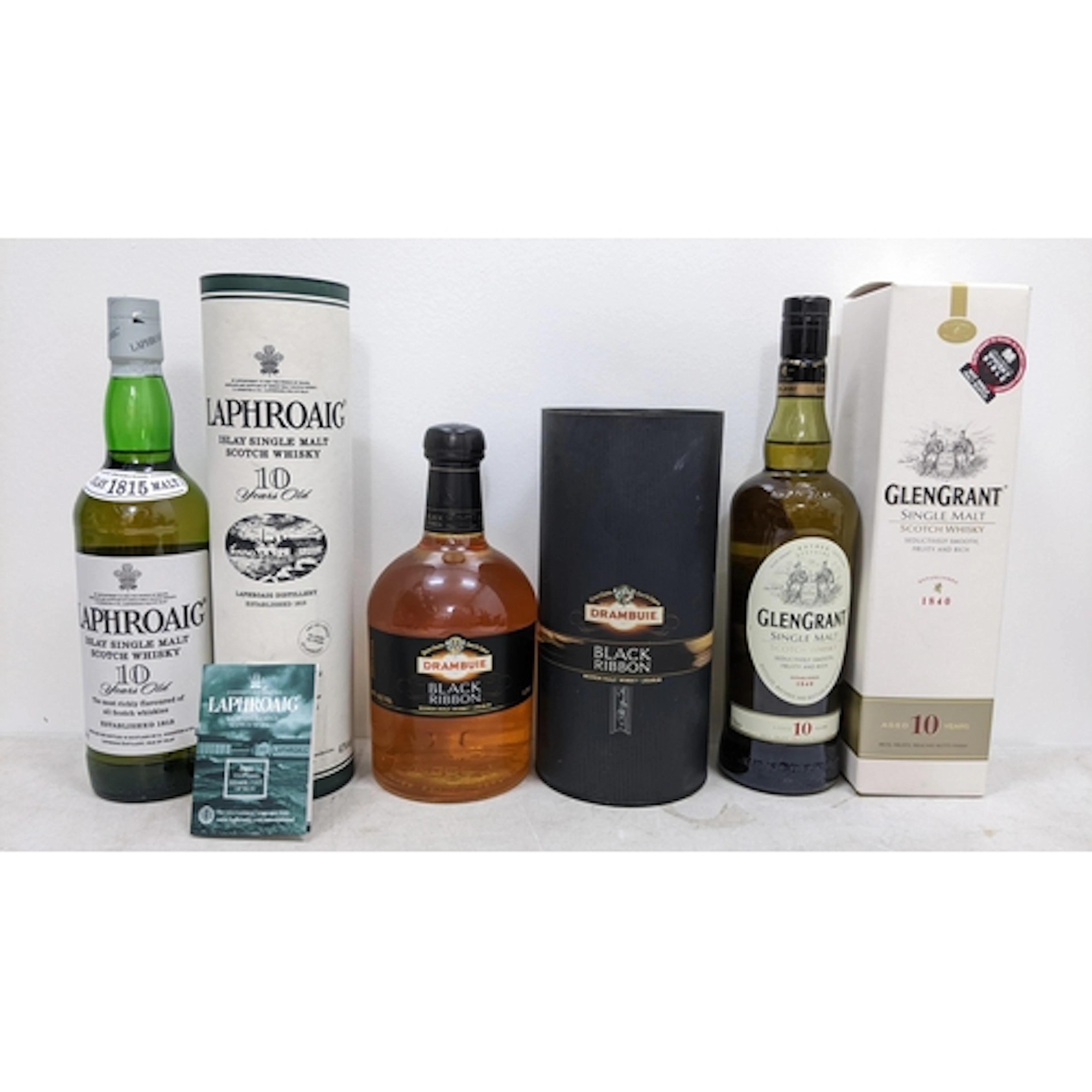 Three boxed bottles of Scotch whisky and whisky liqueur, com...