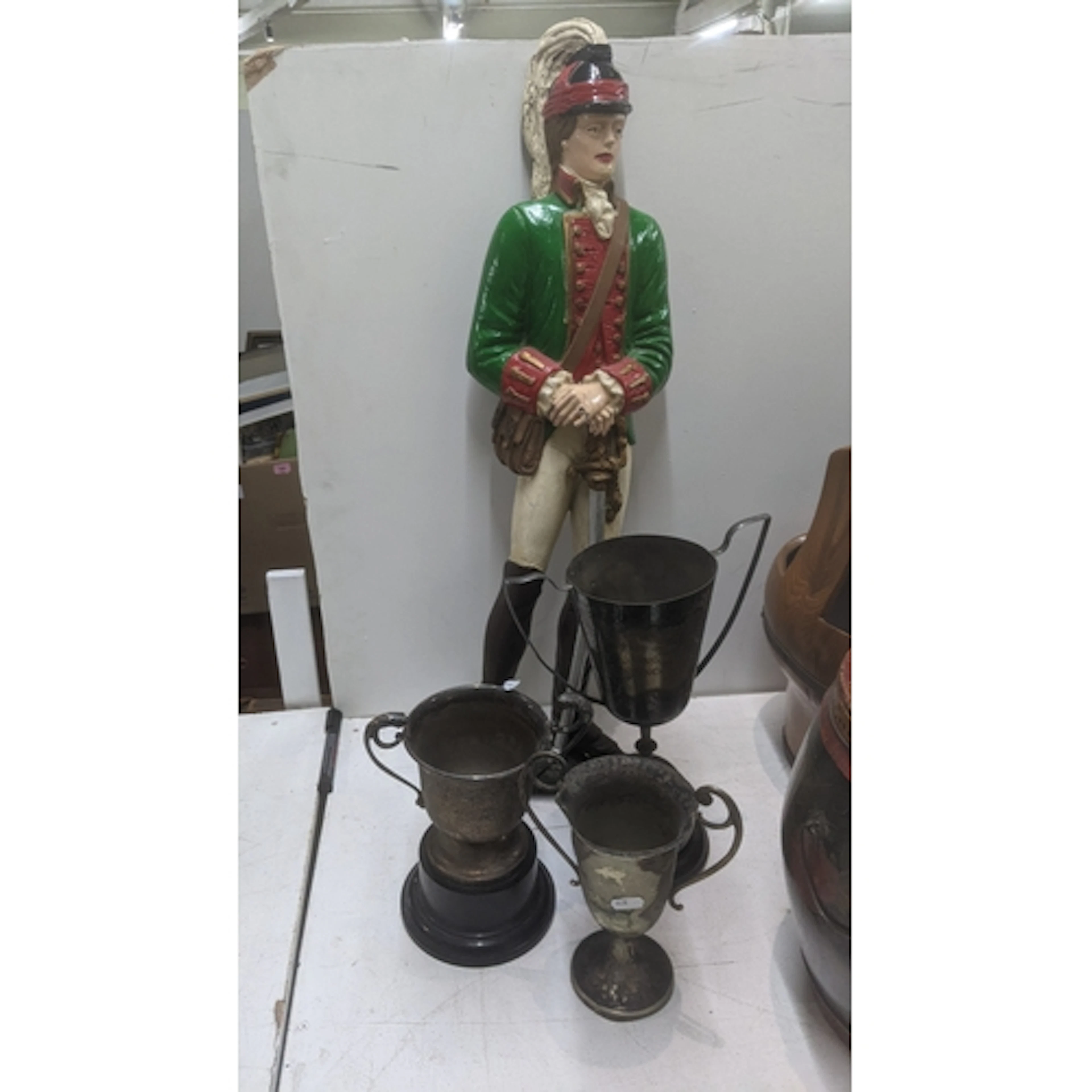 A resin cast figure of a soldier, along with three twin hand...