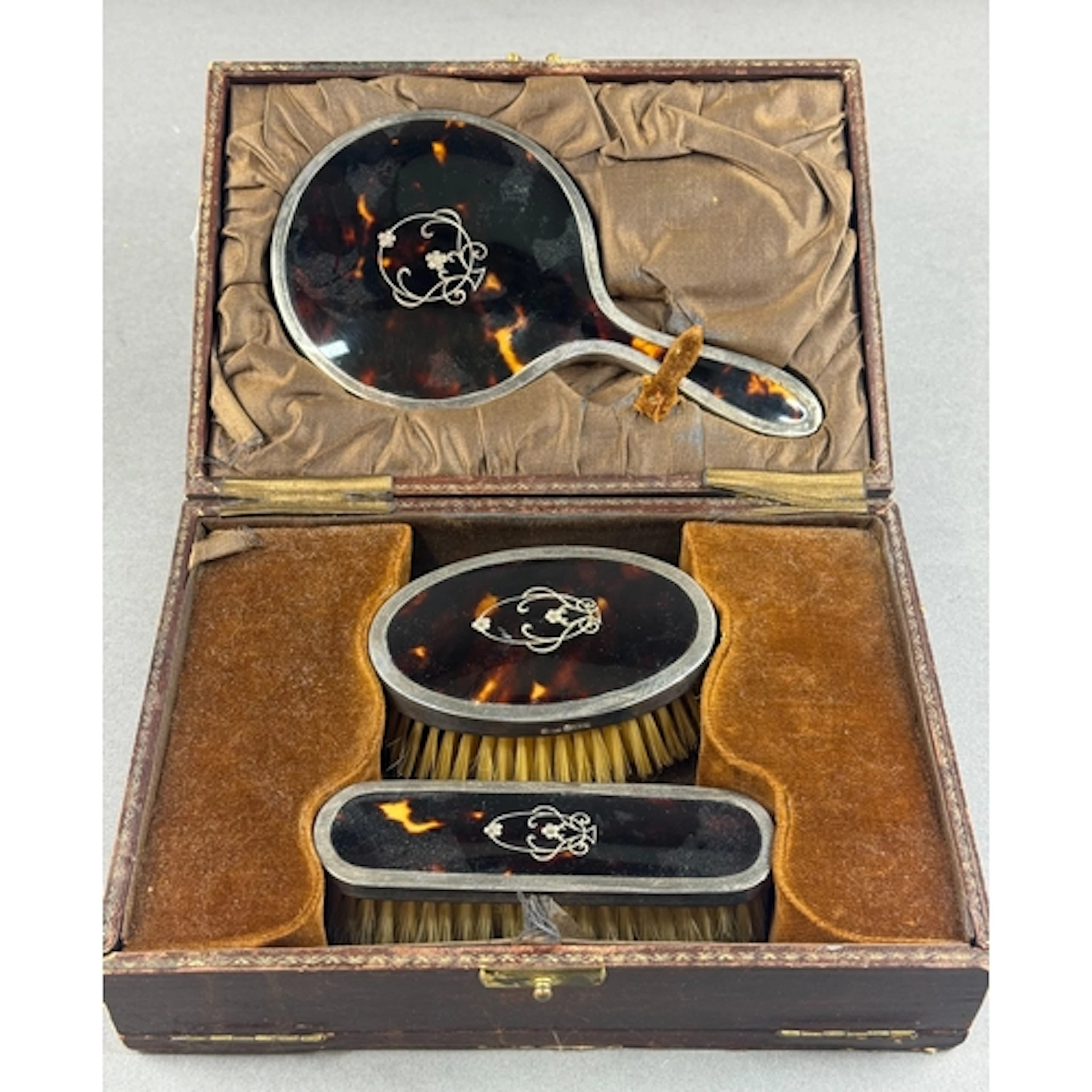 Silver: a silver mounted tortoiseshell dressing table set by...