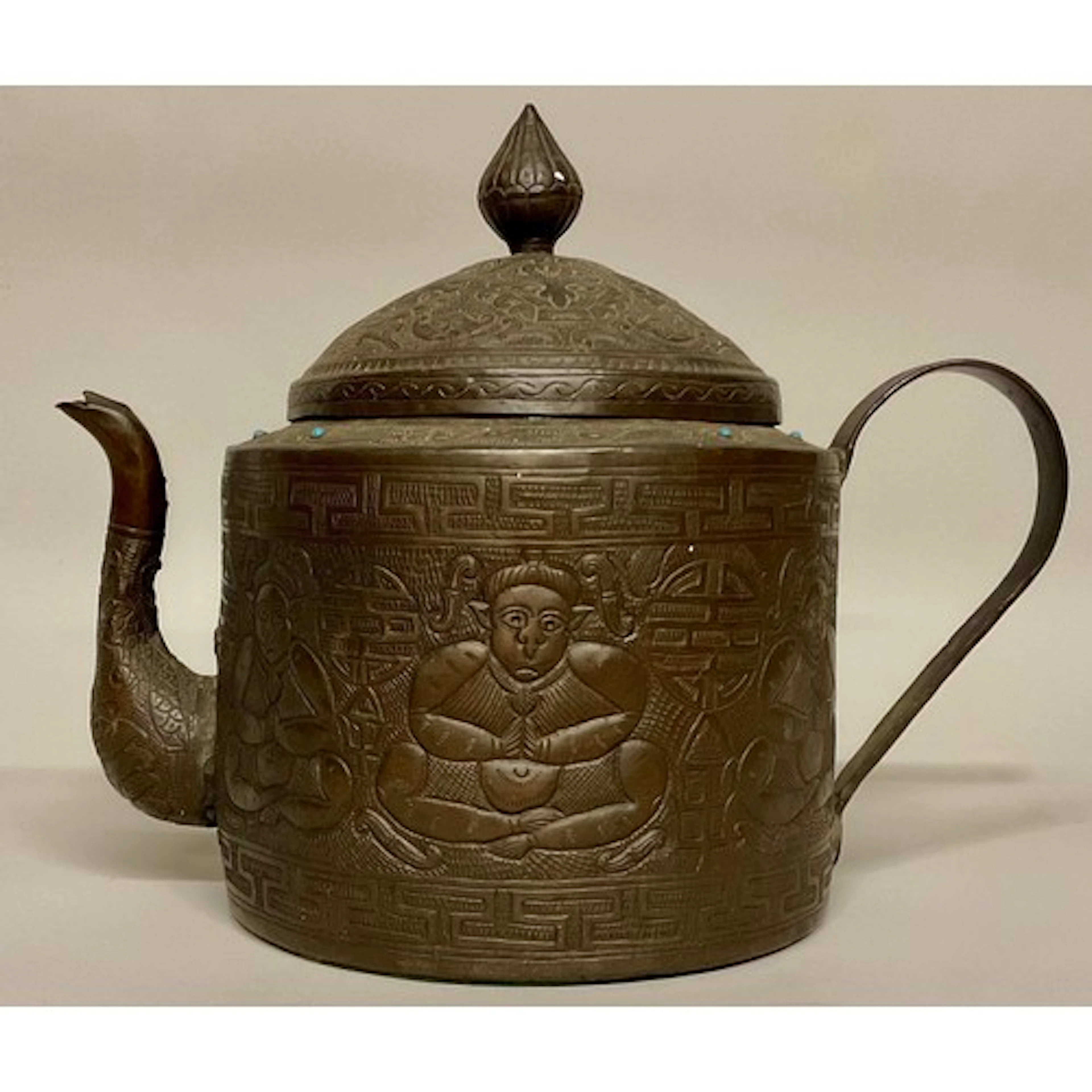 A large Tibetan copper teapot or kettle, profusely chased wi...