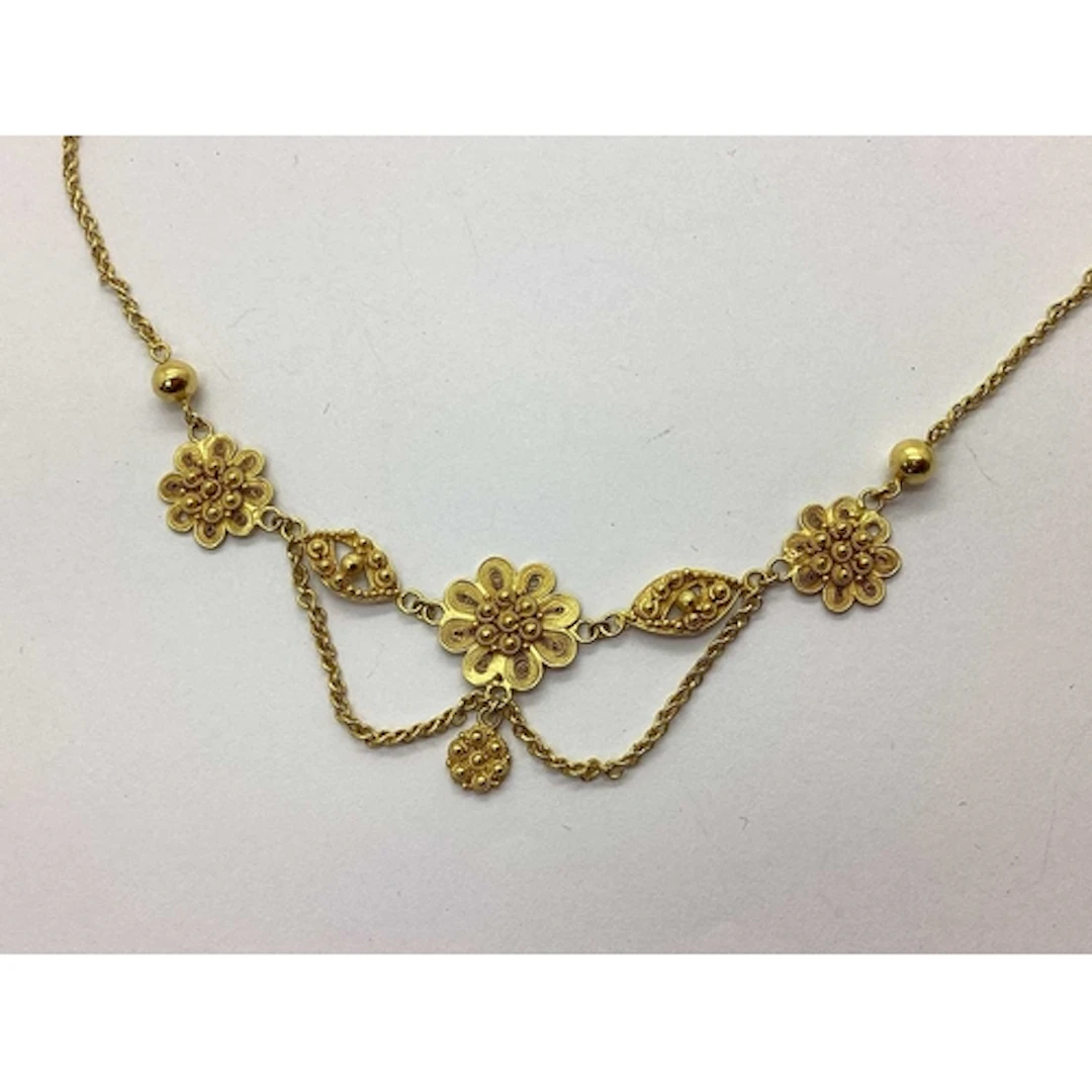 A Decorative Necklace, of filigree flowerhead design suspend...