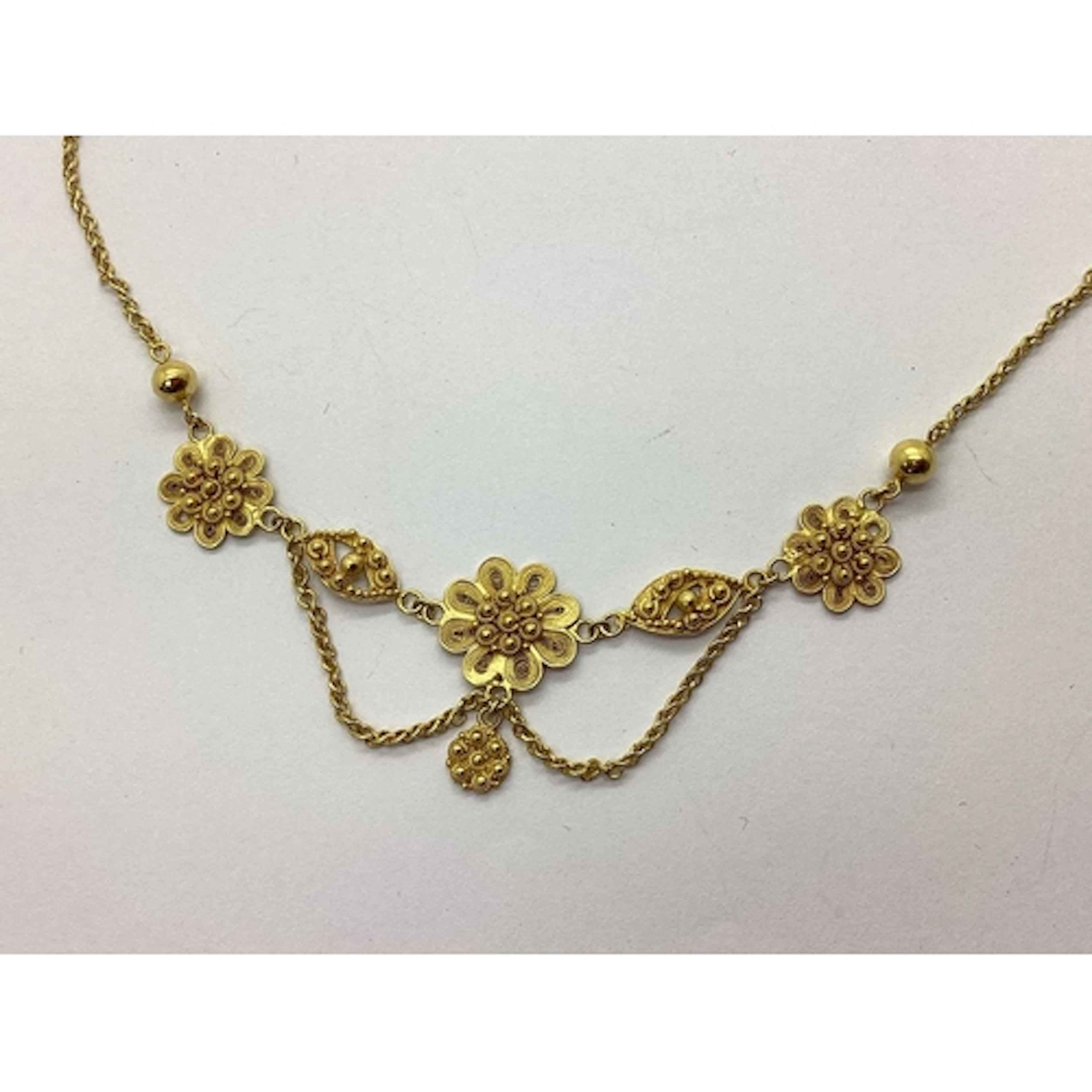 A Decorative Necklace, of filigree flowerhead design suspend...