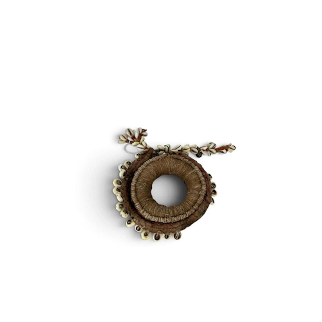 AN EARLY 20TH CENTURY INDIAN PADDED COIL DECORATED WITH COWR...