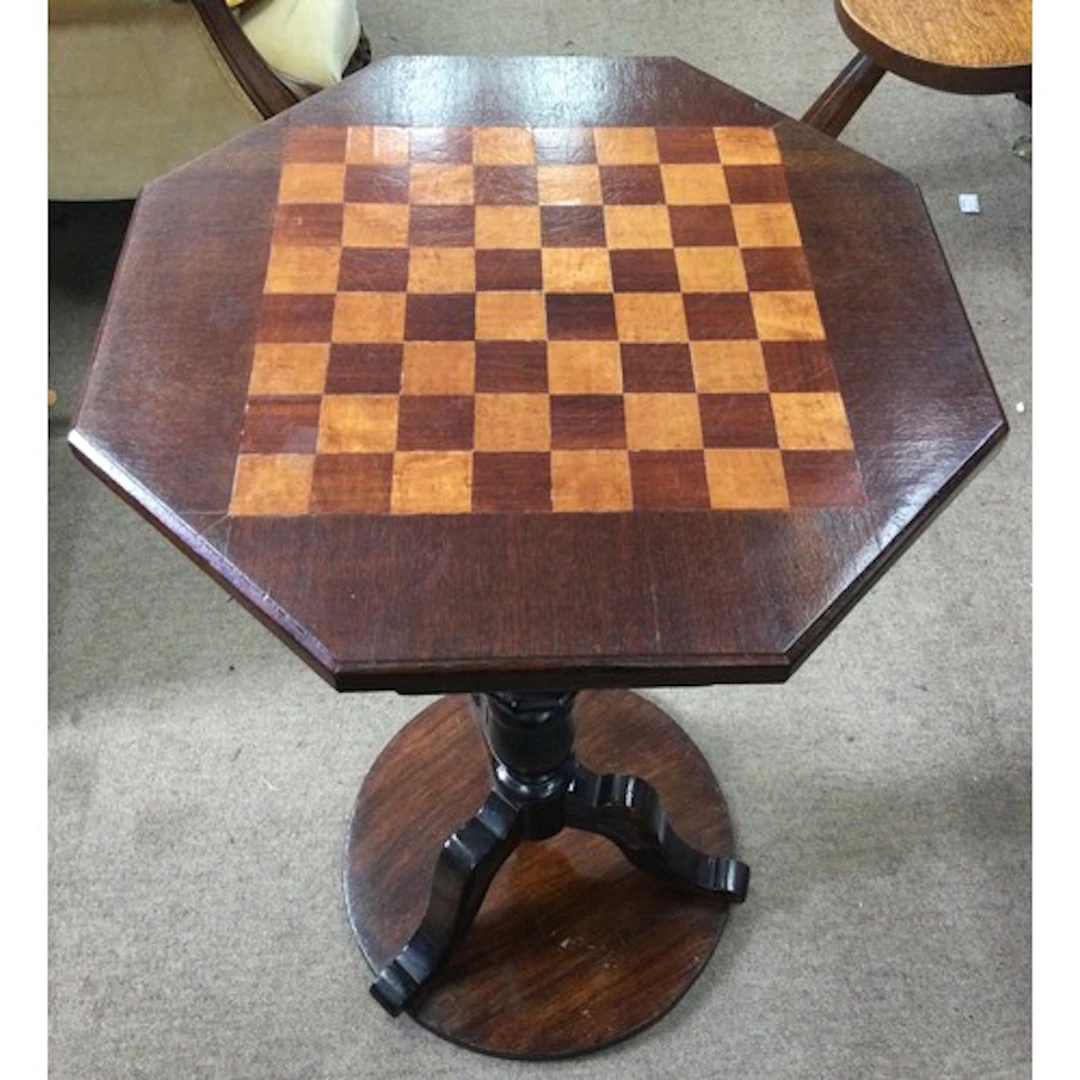 A hexagonal games table with chequerboard top on tripod base...