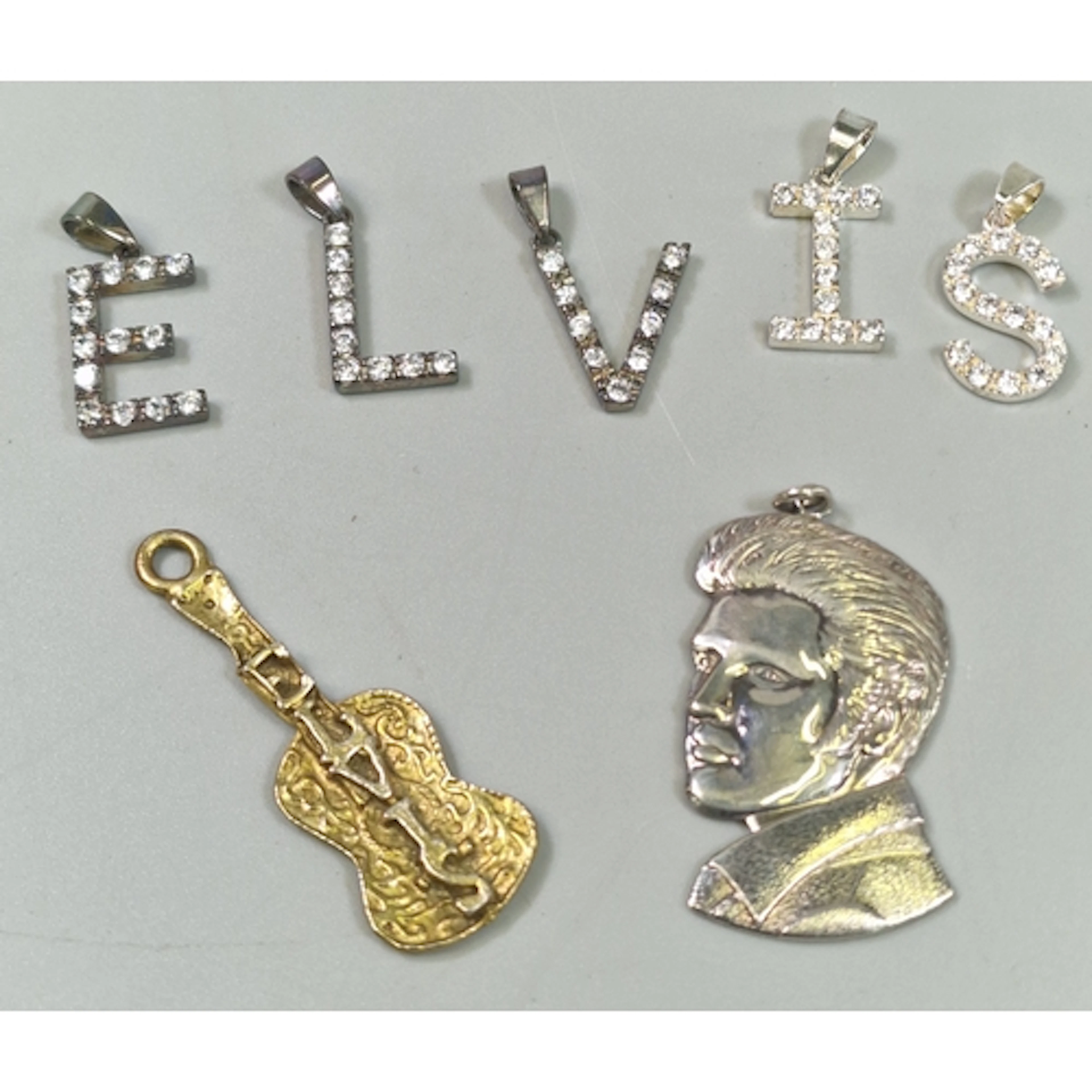 Collection of Elvis Presley charms or pendants, one a silver...