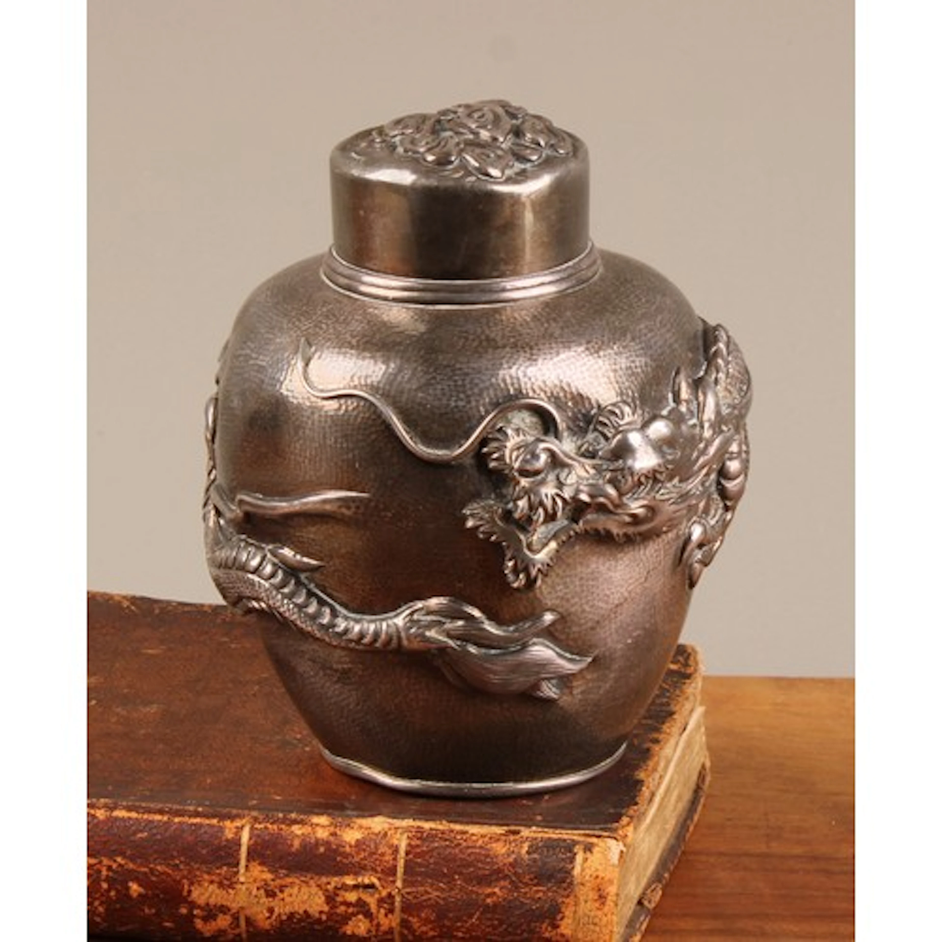 A Japanese silver ovoid tea caddy, repousse chased in bold r...