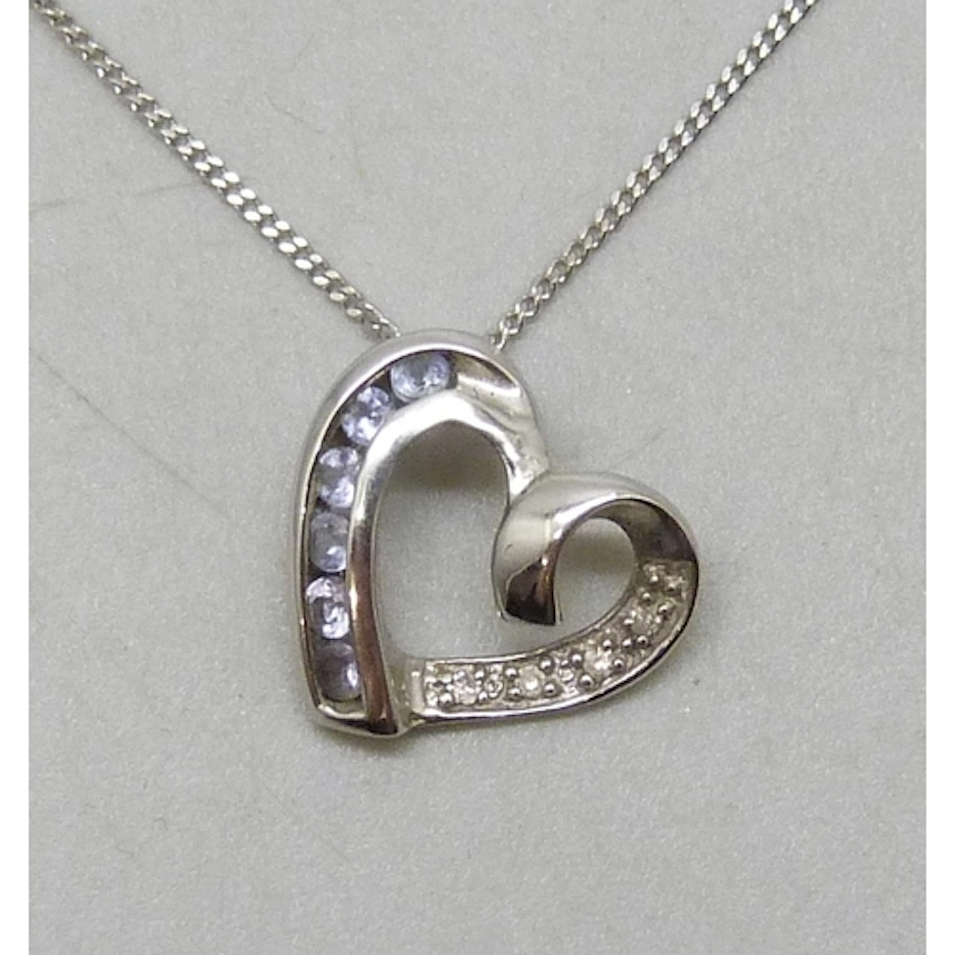 A 9ct white gold, diamond and iolite pendant, 1.1cm, on a 9c...