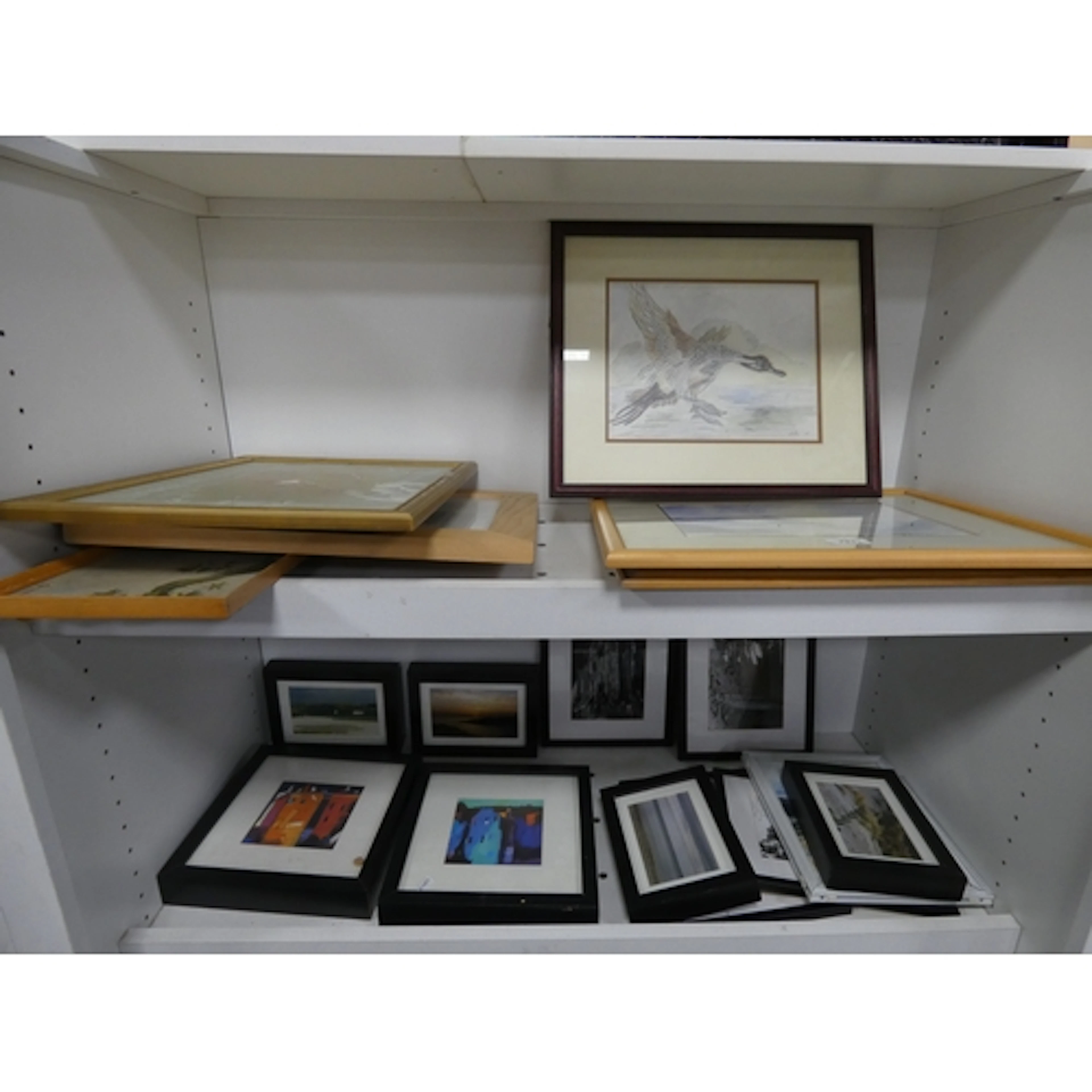 Two shelves of prints and pictures to include an etching of ...