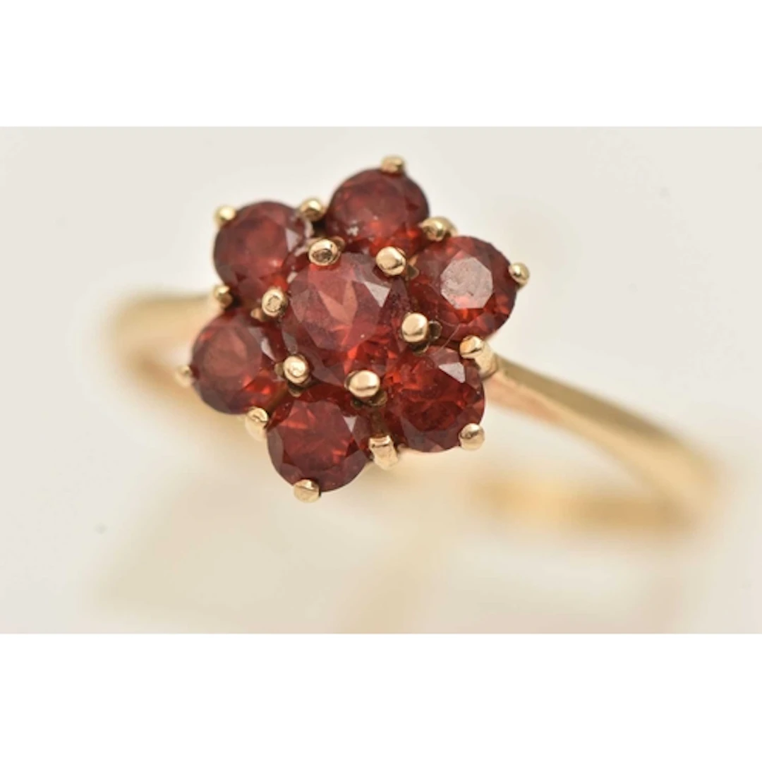 A 9CT GOLD GARNET CLUSTER RING, flower shape cluster set wit...