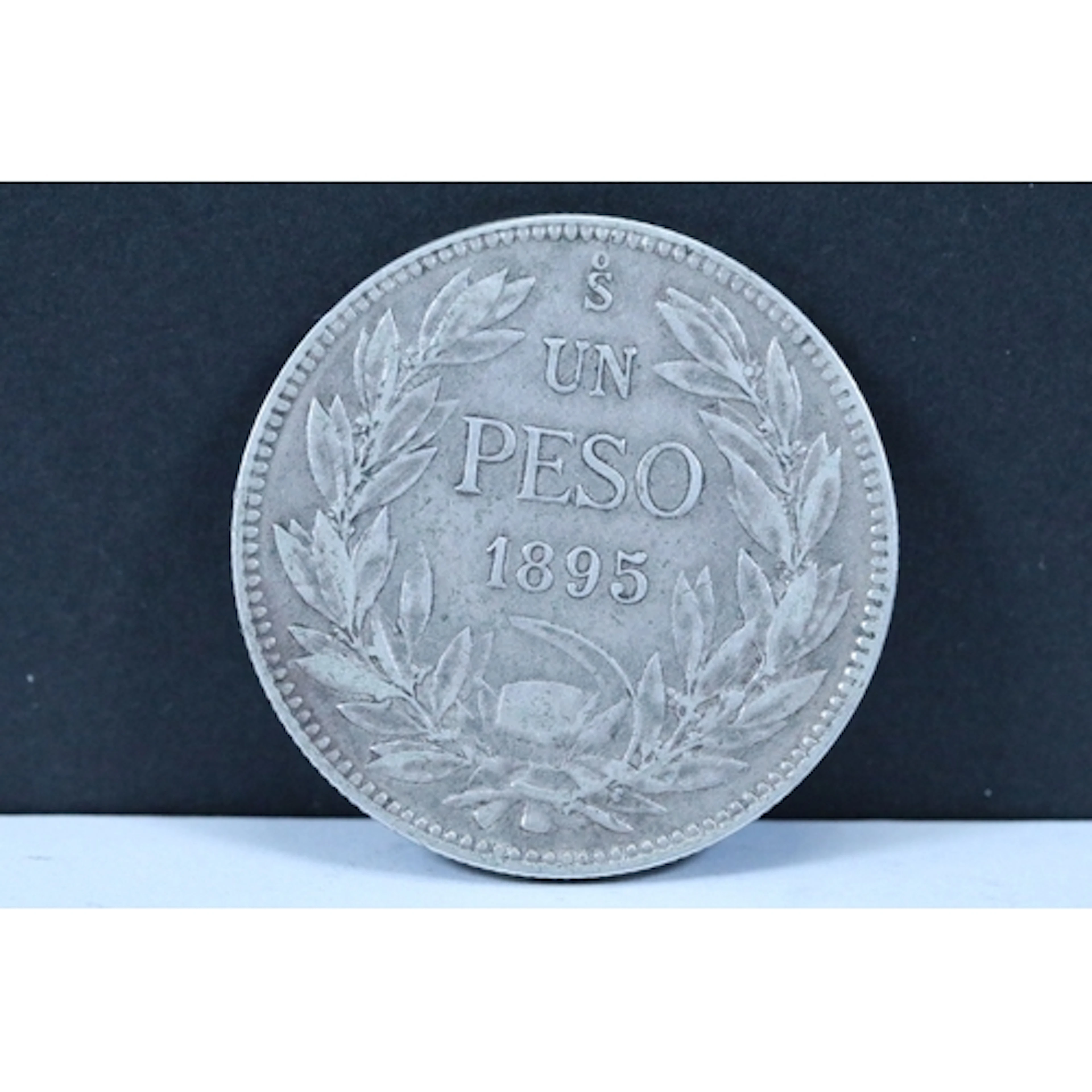 A Chilean 1895 Un Peso silver coin, Obverse : Condor on a ro...