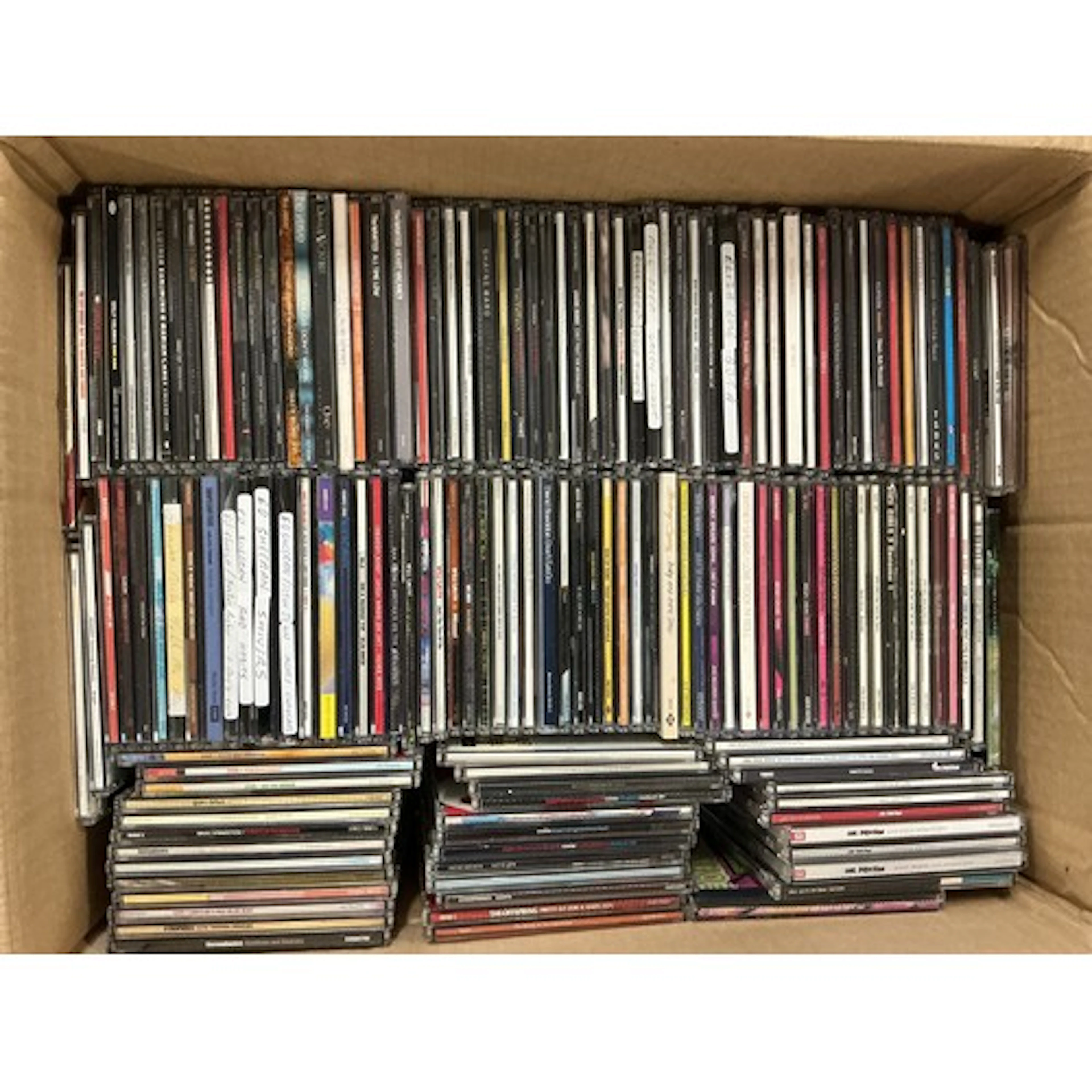 A box and a bag of CD singles by various artists including T...