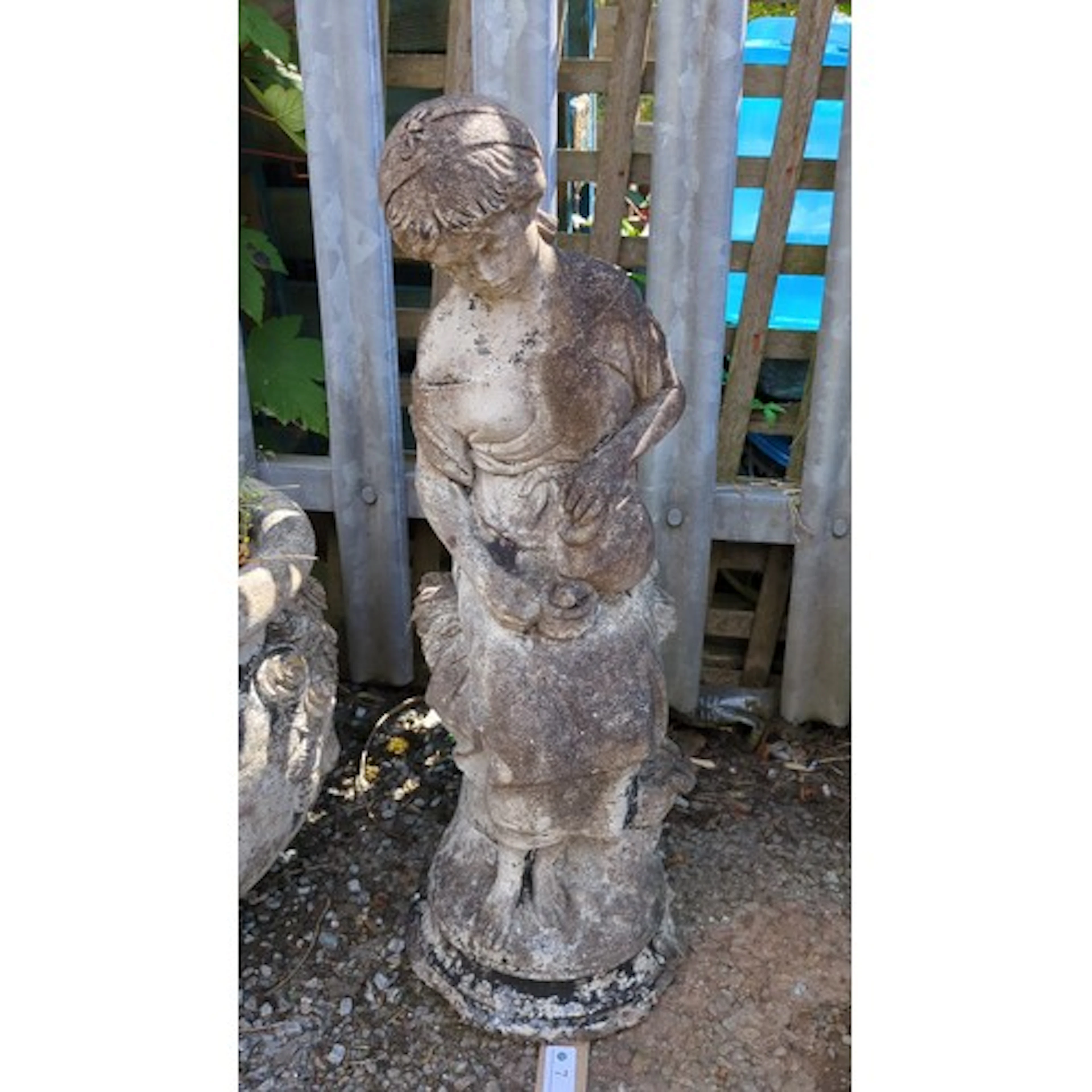 Concrete garden figure modelled as a peasant girl, her head ...