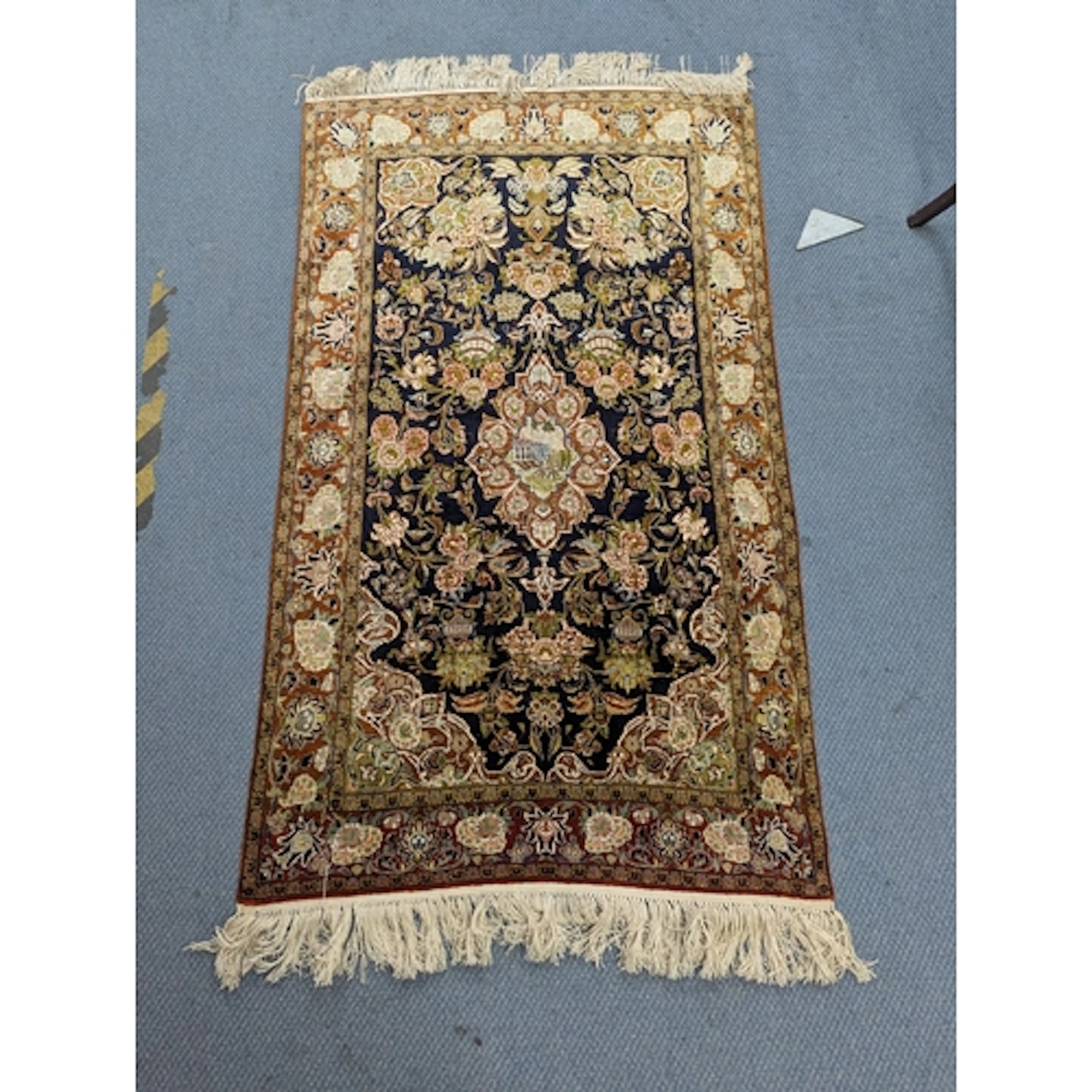 An Egyptian hand woven silk rug on blue ground with floral m...