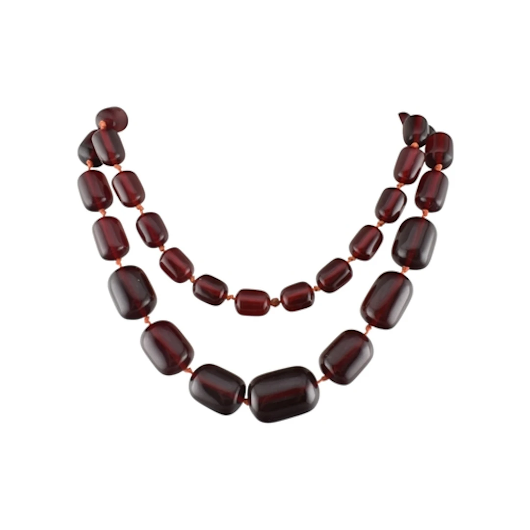 An early red plastic bead necklace. The necklace with knotte...