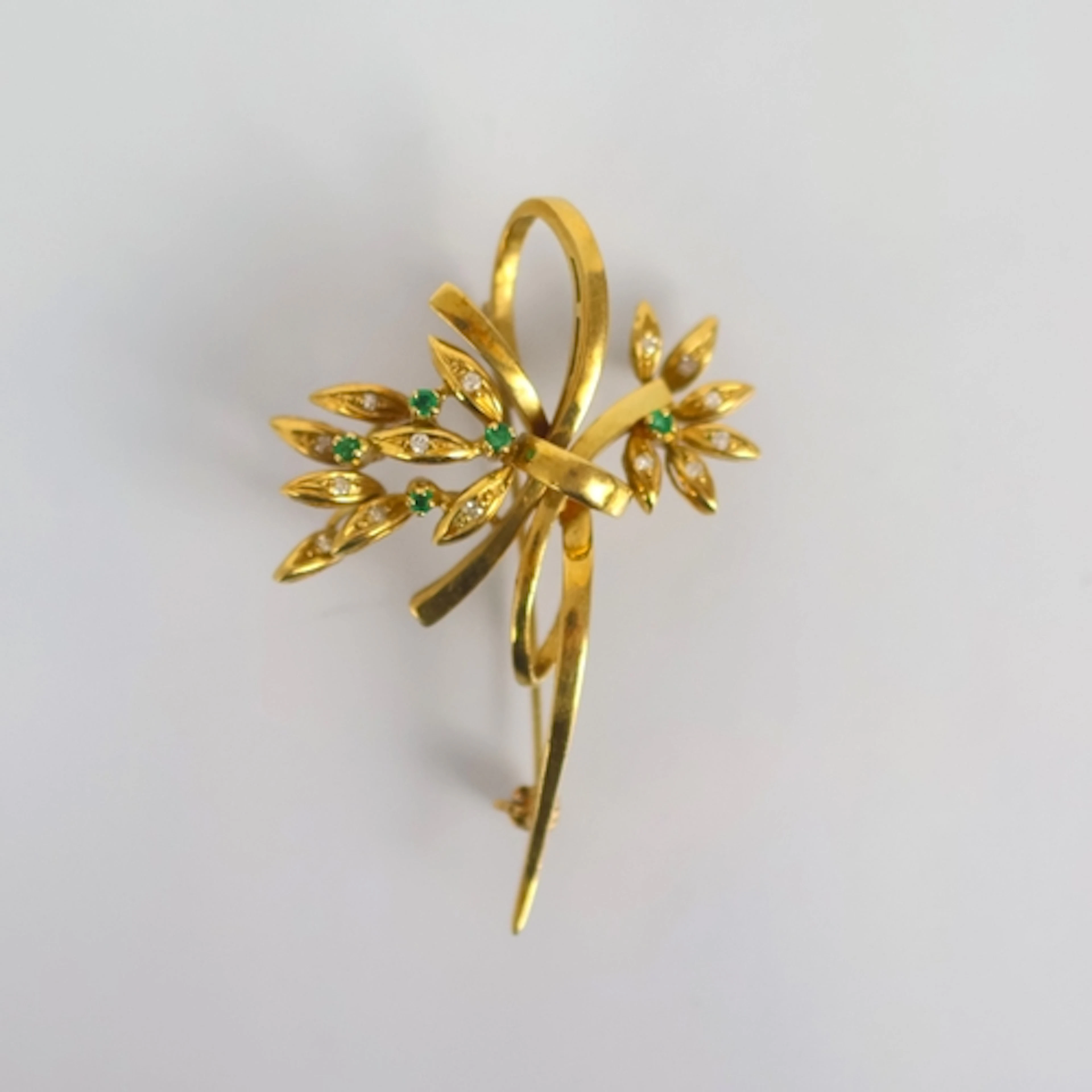 A late 20th century emerald and diamond spray brooch, of sty...