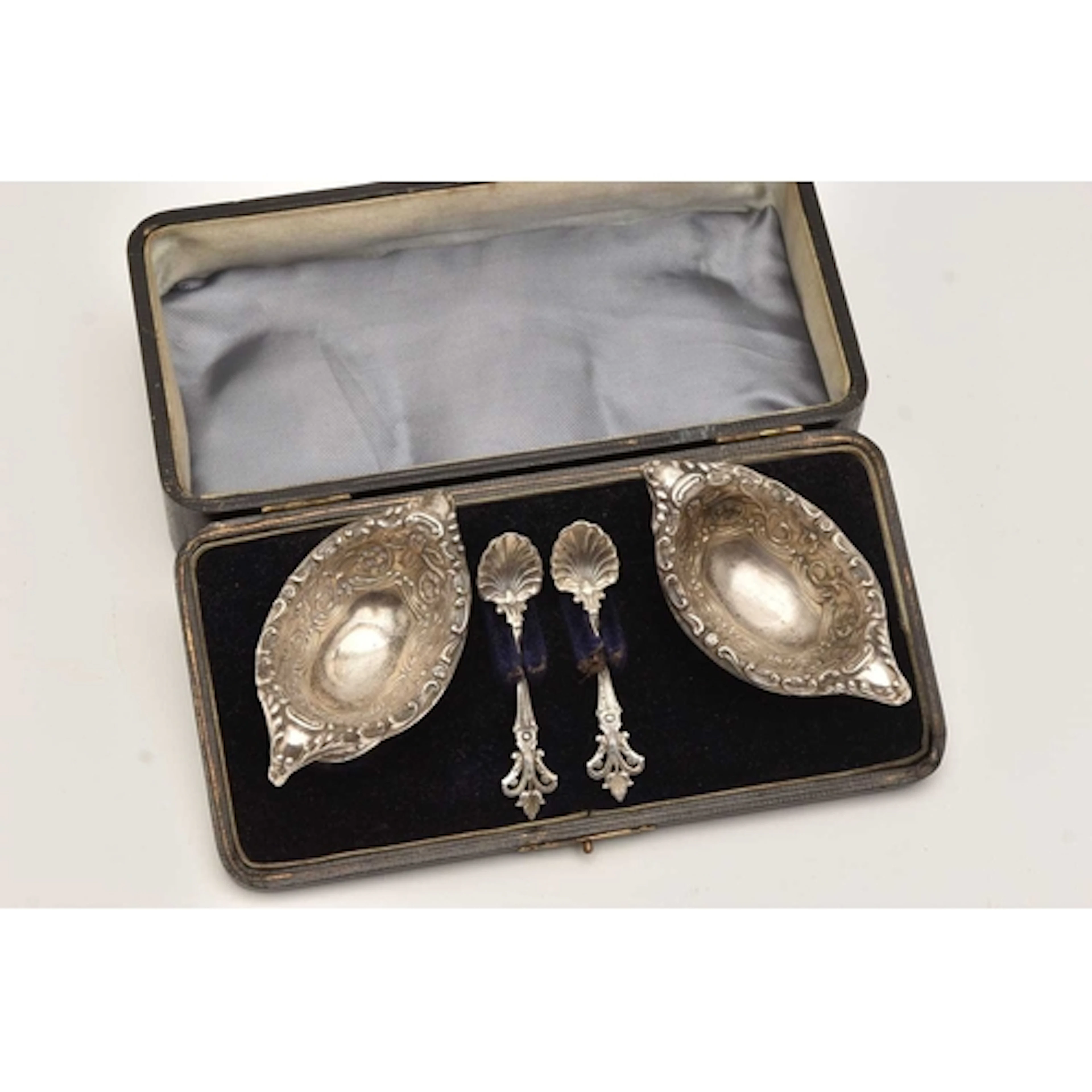 A CASED PAIR OF LATE VICTORIAN SILVER SALTS, each of an oval...
