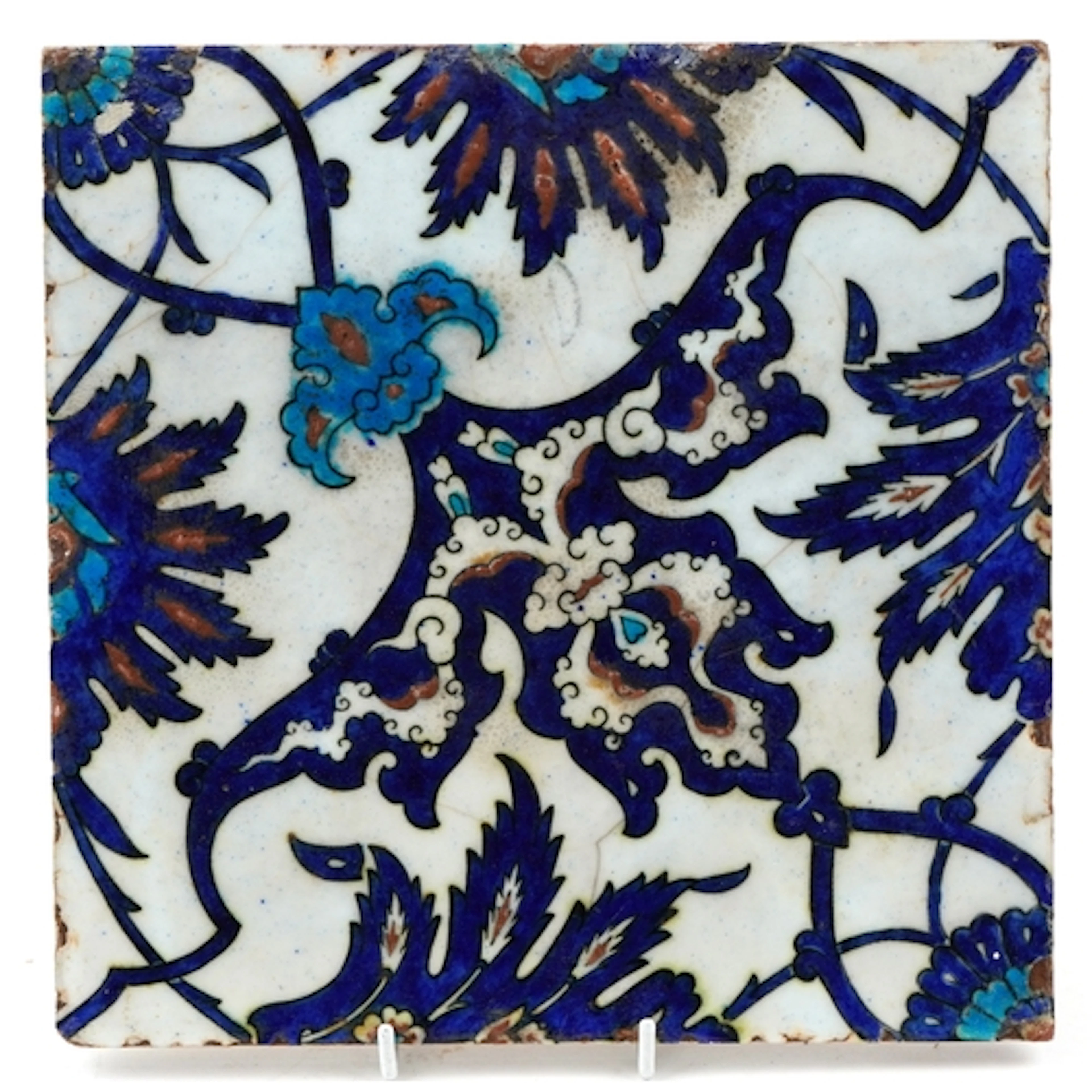 A Turkish Ottoman Iznik pottery tile hand painted with folia...