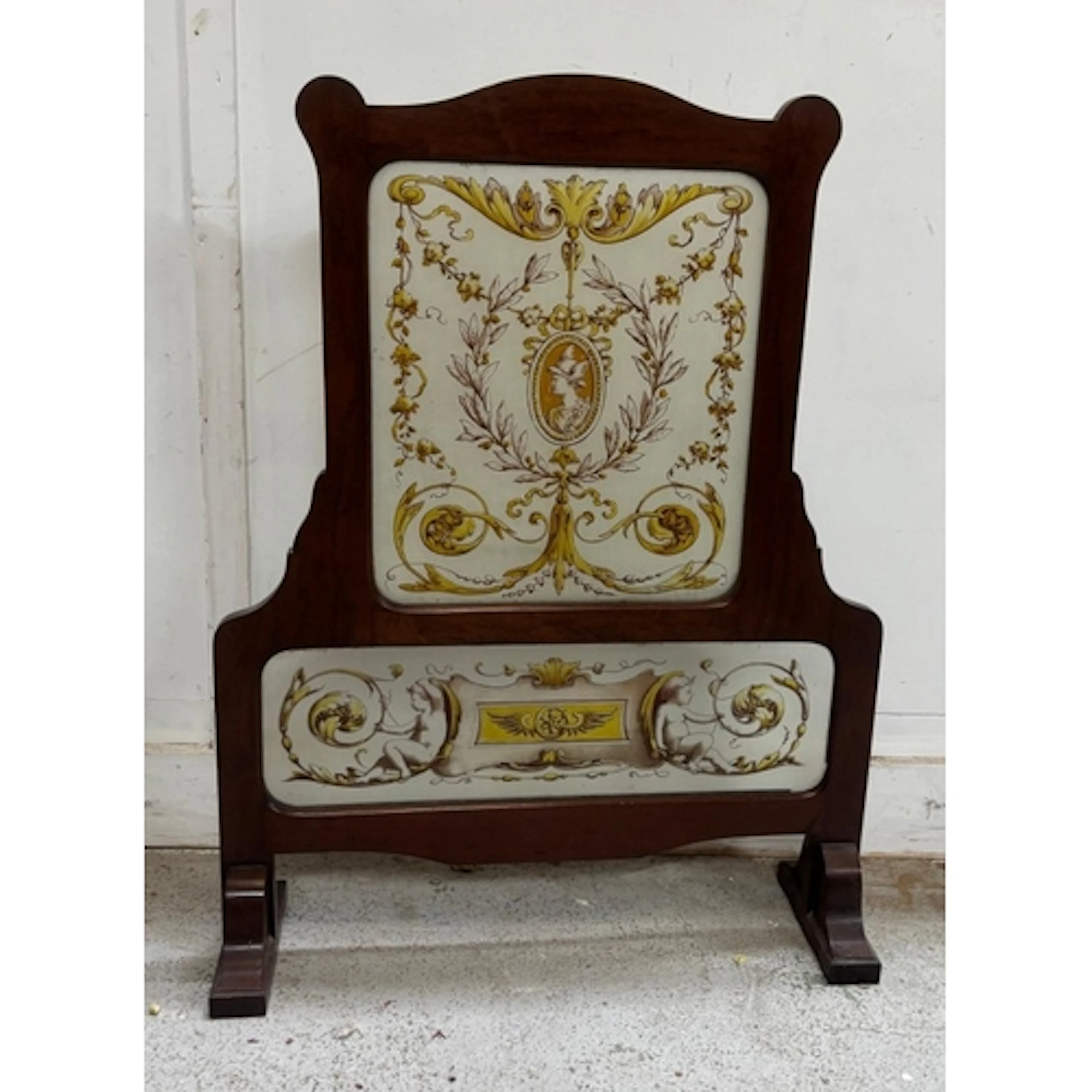 An ornate classical fire screen featuring painted glass pane...