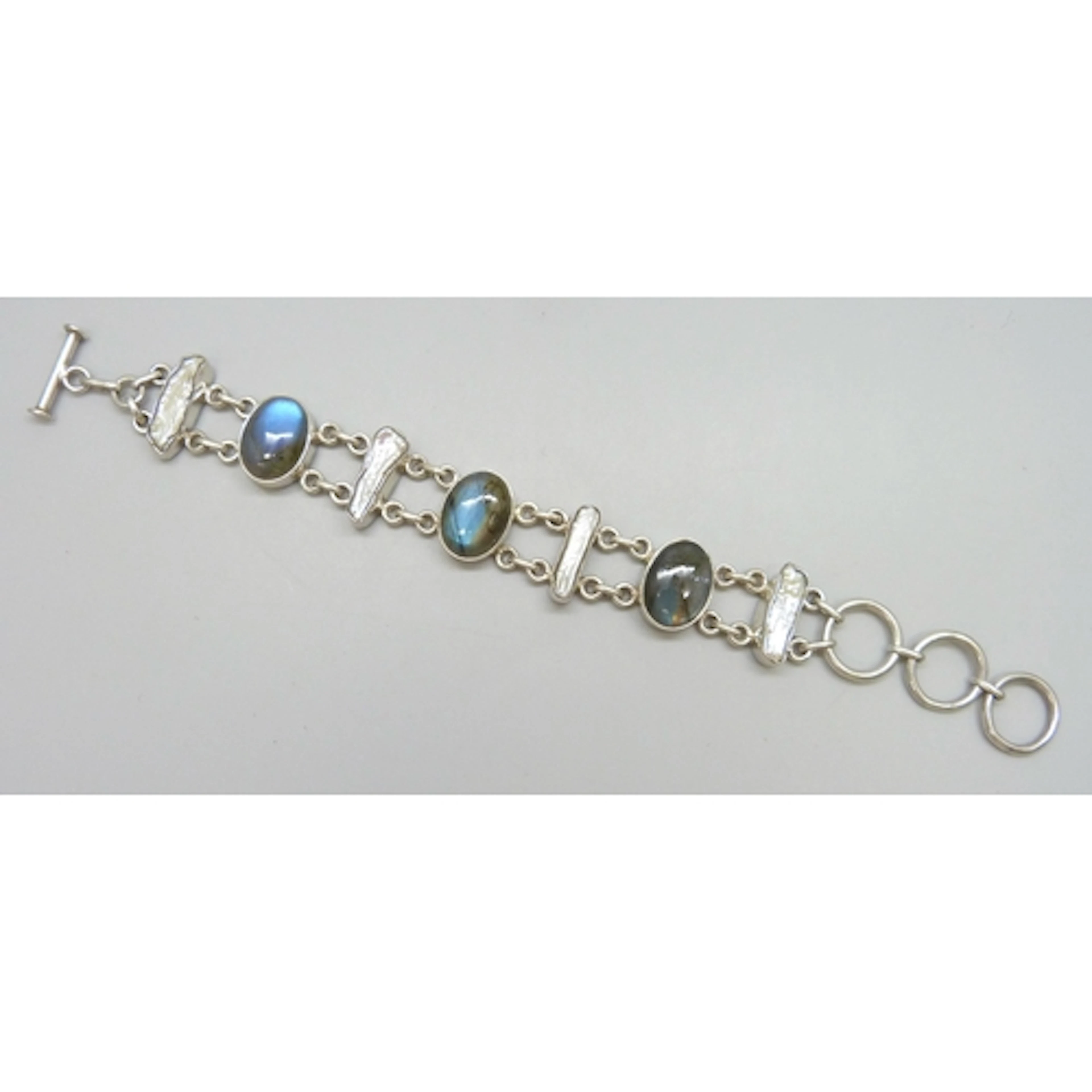 A silver bracelet set with cabochon labradorite stones and k...