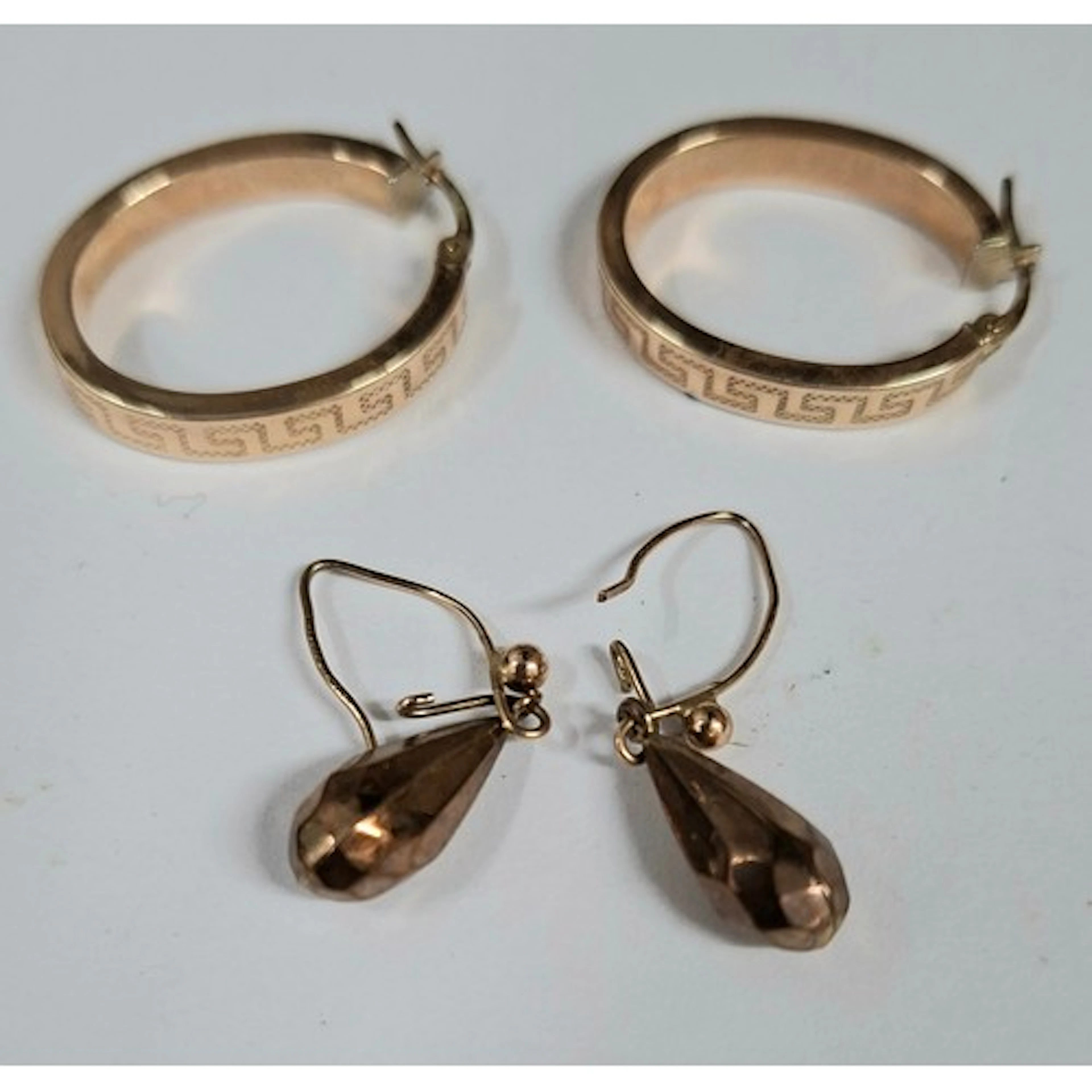 Two pairs of 9ct gold earrings comprising a pair of hoops wi...