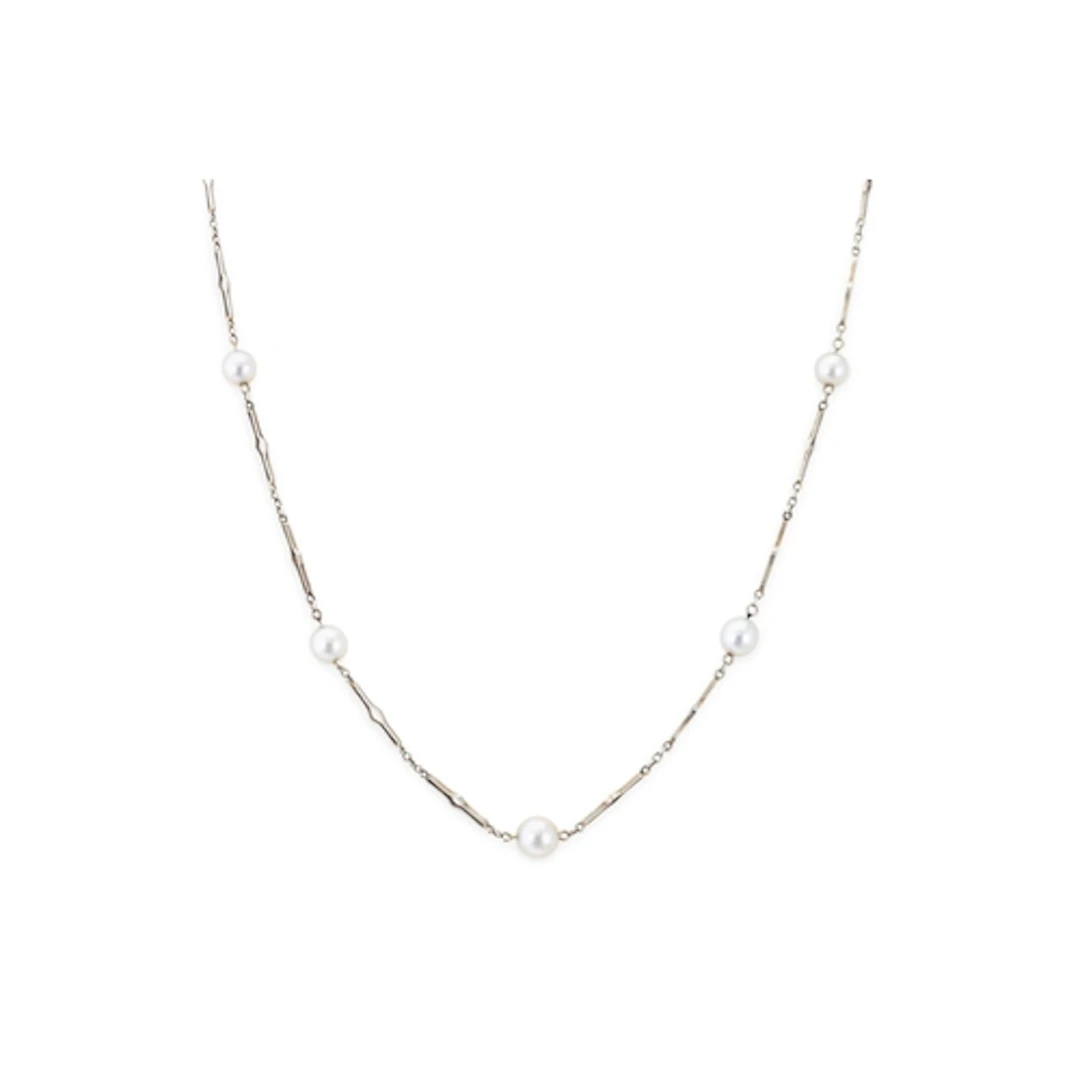 AN ART DECO 18CT WHITE GOLD STATION NECKLACE, set with seven...