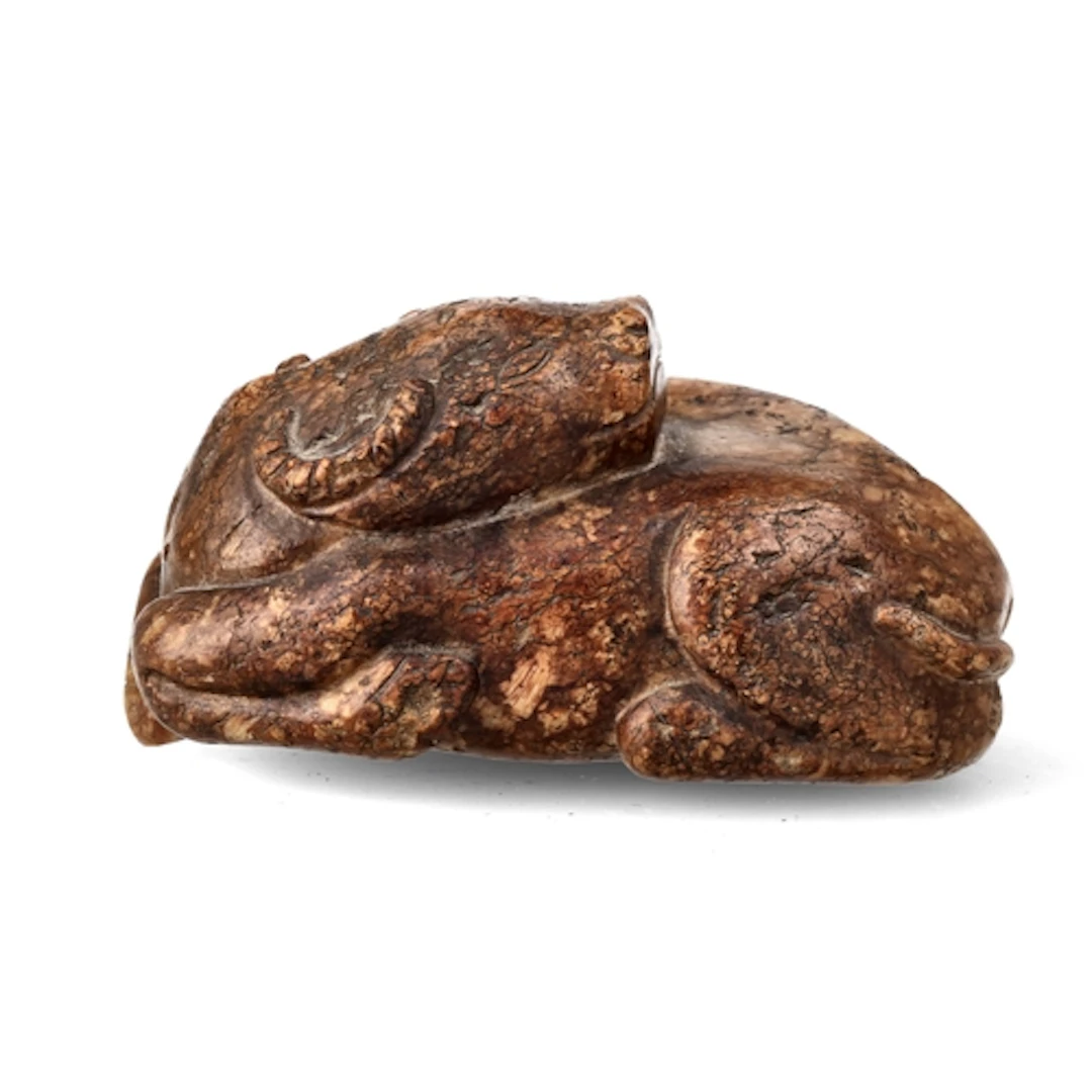 A CHINESE RUSSET JADE CARVING OF A WATER BUFFALO, 19TH CENTU...