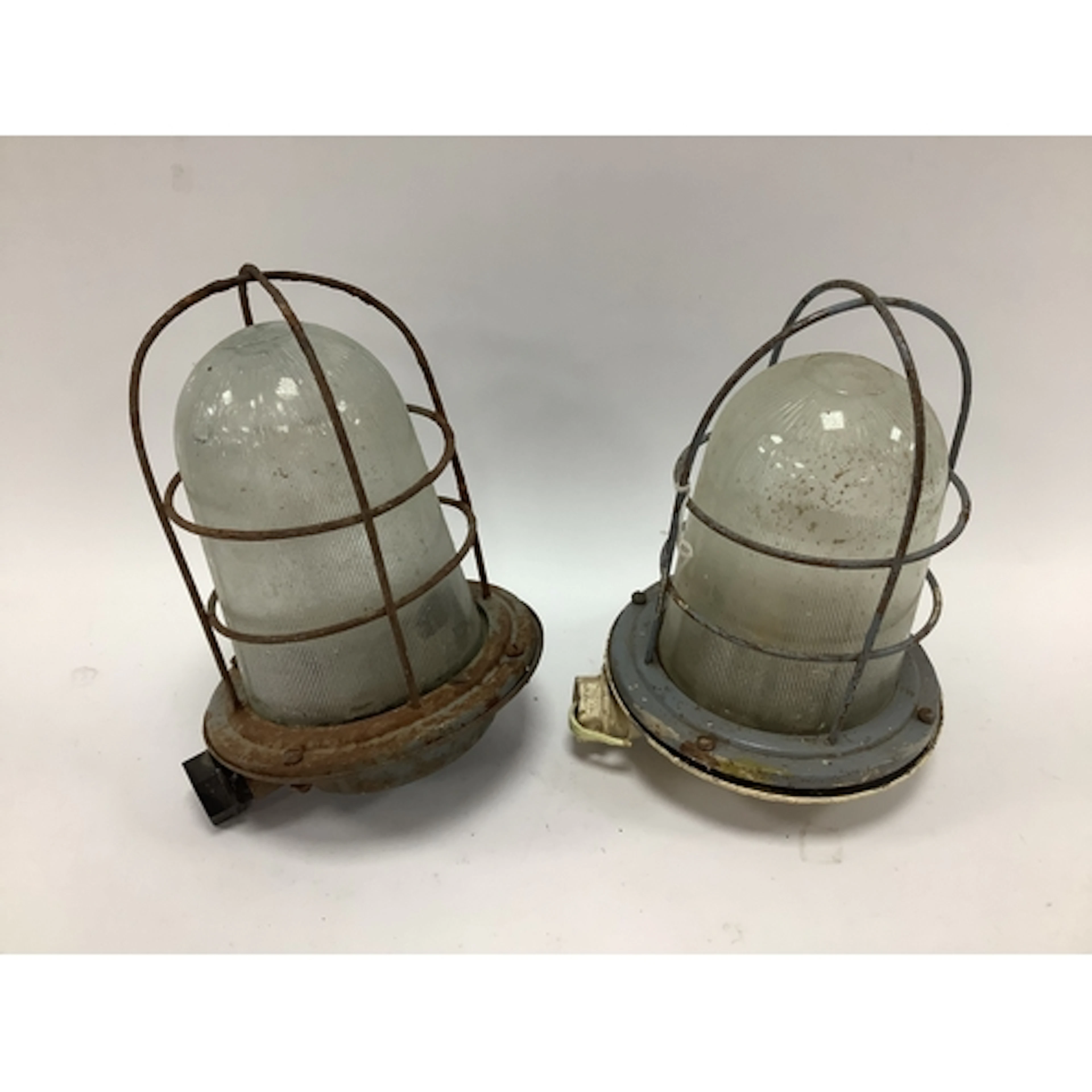 A pair of vintage industrial bulkhead lamps, featuring ribbe...