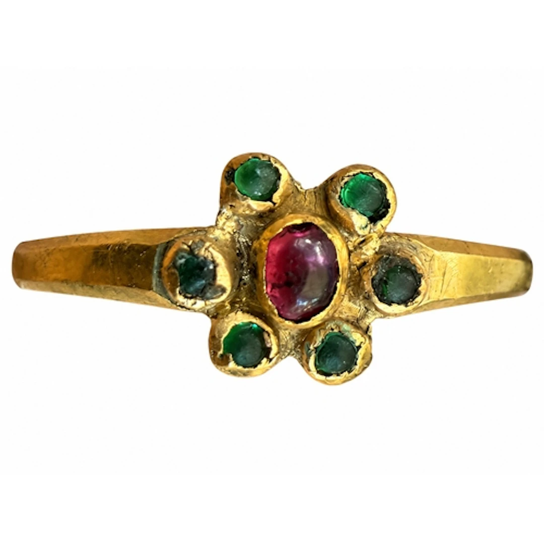 A slender medieval gold ring with a flowerhead bezel, centre...