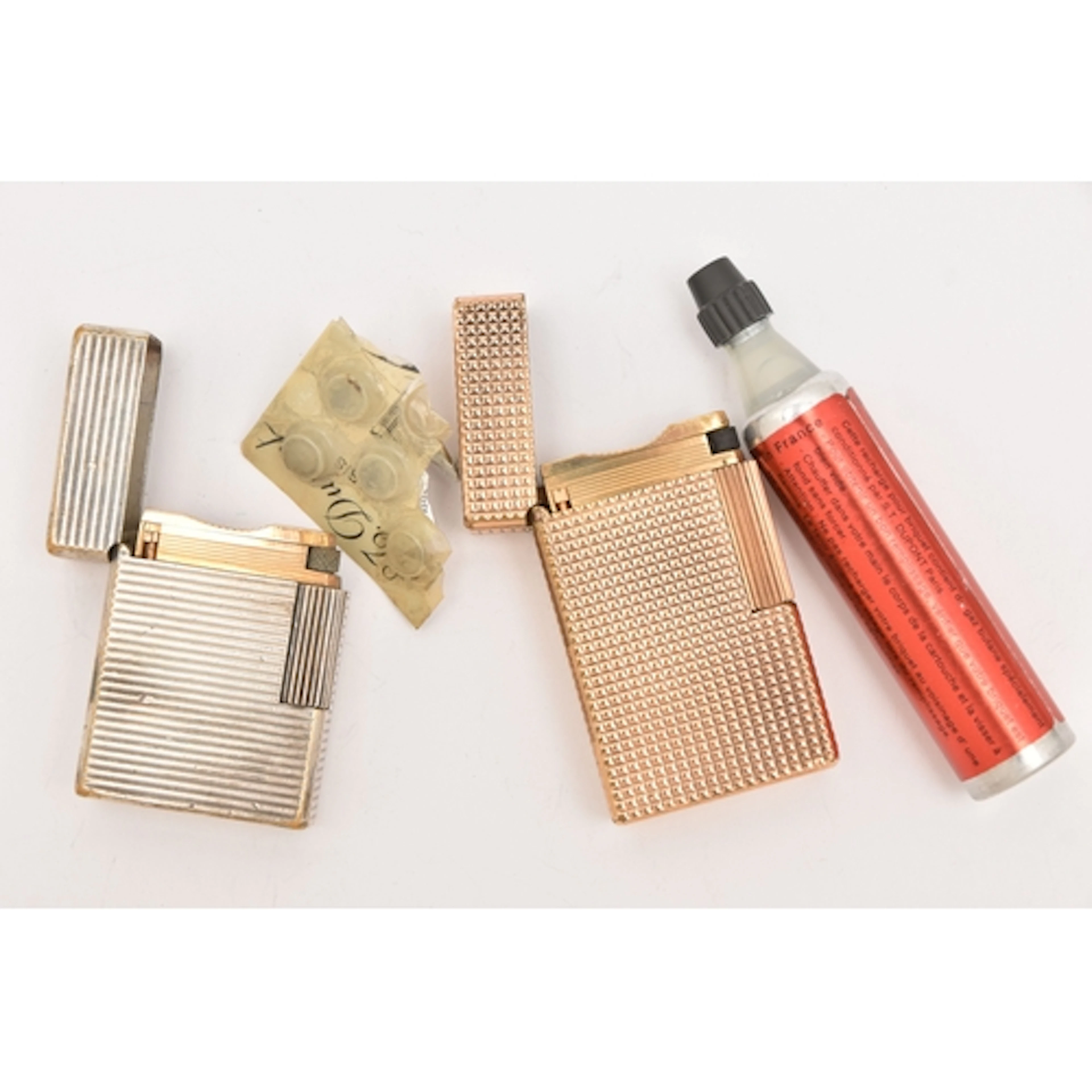 TWO 'S.T.DUPONT' LIGHTERS, the first a gold plated engine tu...