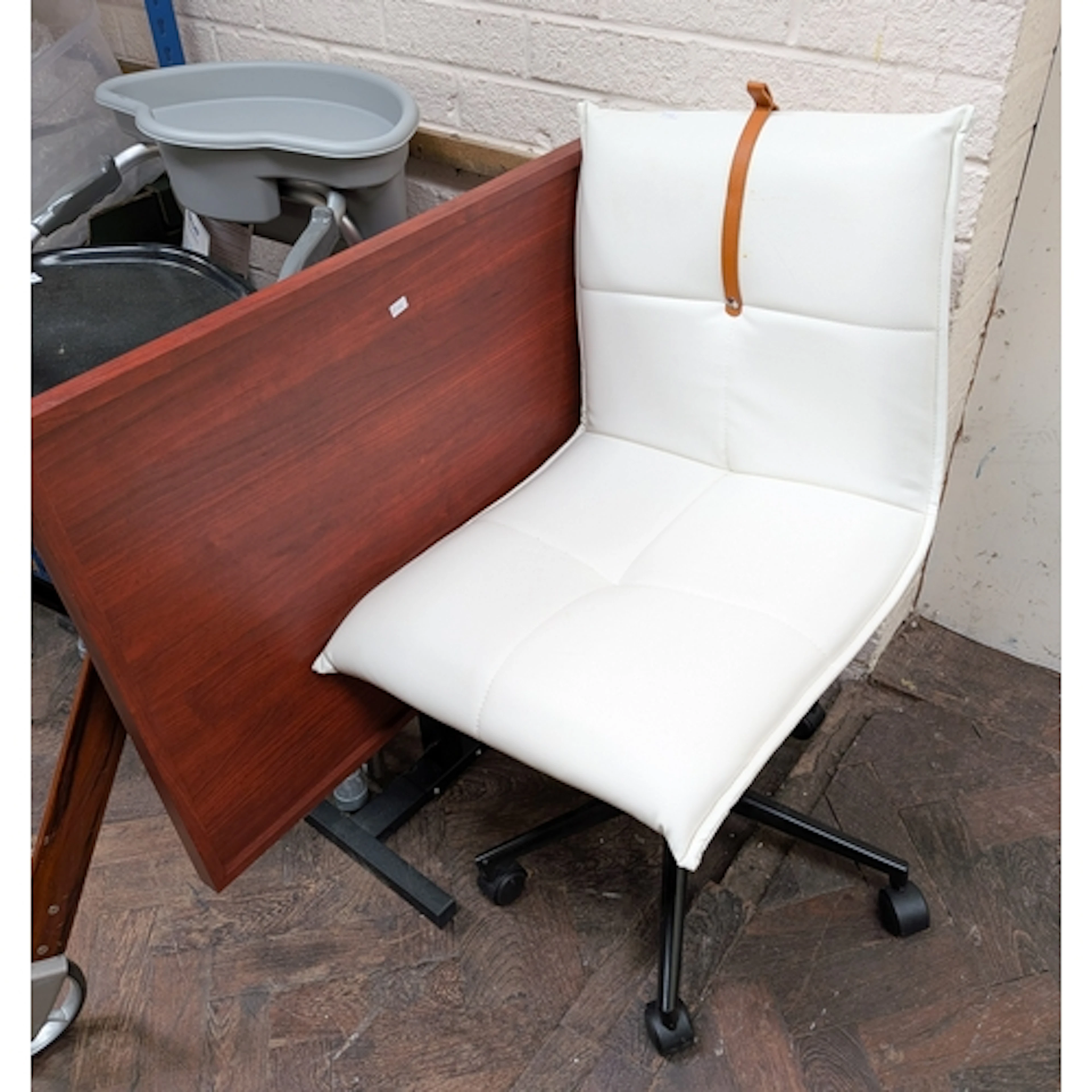 A white faux leather office chair and a folding table