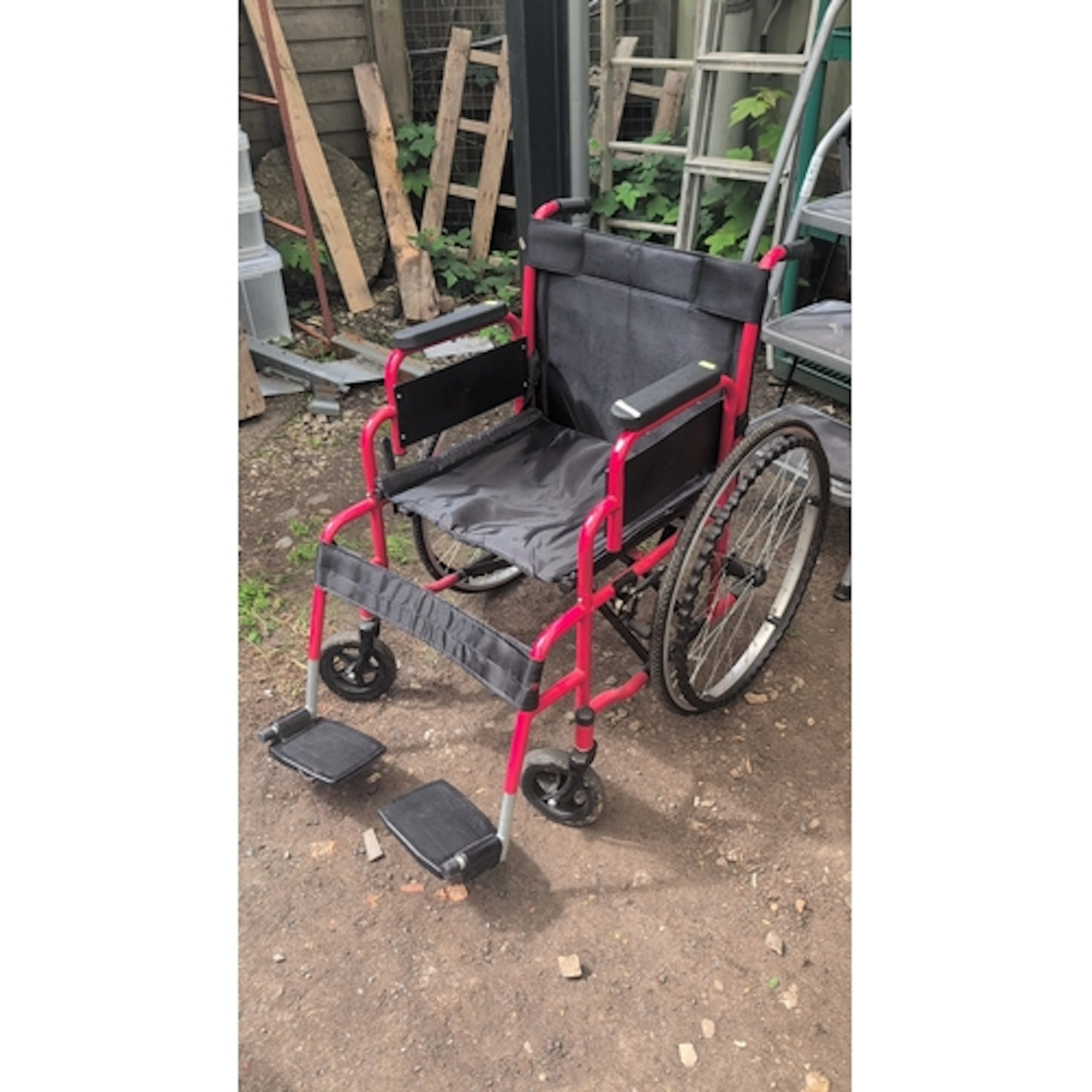 All Aid folding transit wheelchair, the red tubular frame wi...