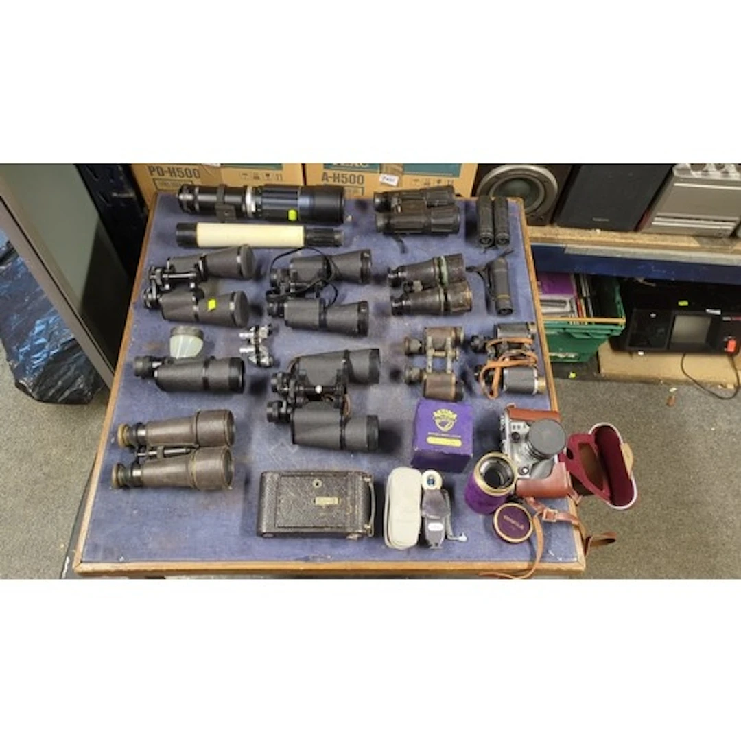 A collection of binoculars and optical equipment, including ...